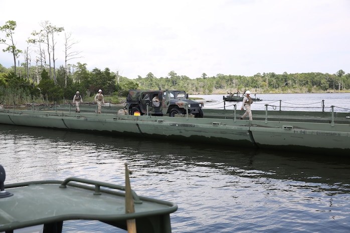 Marines with Bridge Company, 8th Engineer Support Battalion, 2nd Marine Logistics Group guide a High Mobility Multipurpose Wheeled Vehicle across a continuous span of 43 Improvised Ribbon Bridges during a training exercise at Engineer Point aboard Camp Lejeune, N.C., July 30, 2013. Approximately 44 soldiers with 502nd Multi Role Bridge Company, based at Fort Knox, Ky., worked with Marines to build a continuous span piece-by-piece using MK III Bridge Erection Boats.