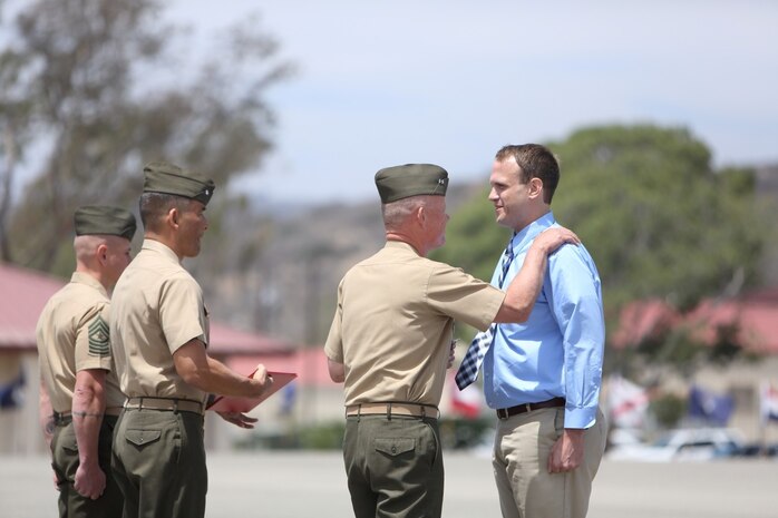 Sergeant Matthew T. Woodall, former squad leader, Bravo Company, 1st Battalion, 5th Marine Regiment, shares a laugh with Maj. Gen. Lawrence Nicholson, commanding general, 1st Marine Division, during an award ceremony at the Camp San Mateo parade deck here, Aug. 2, 2013. Woodall, a native of Paducah, Ky., earned the Silver Star Medal, the nation's third highest military award for valor for his actions in Helmand province, Afghanistan, in support of Operation Enduring Freedom. A platoon-sized enemy force attacked Woodall and his Marines from several fortified positions during a security patrol mission in the Sangin district of Helmand, July 10 through 11, 2011. His daring actions ultimately defeated the enemy attack, killing four insurgents and wounding many others.