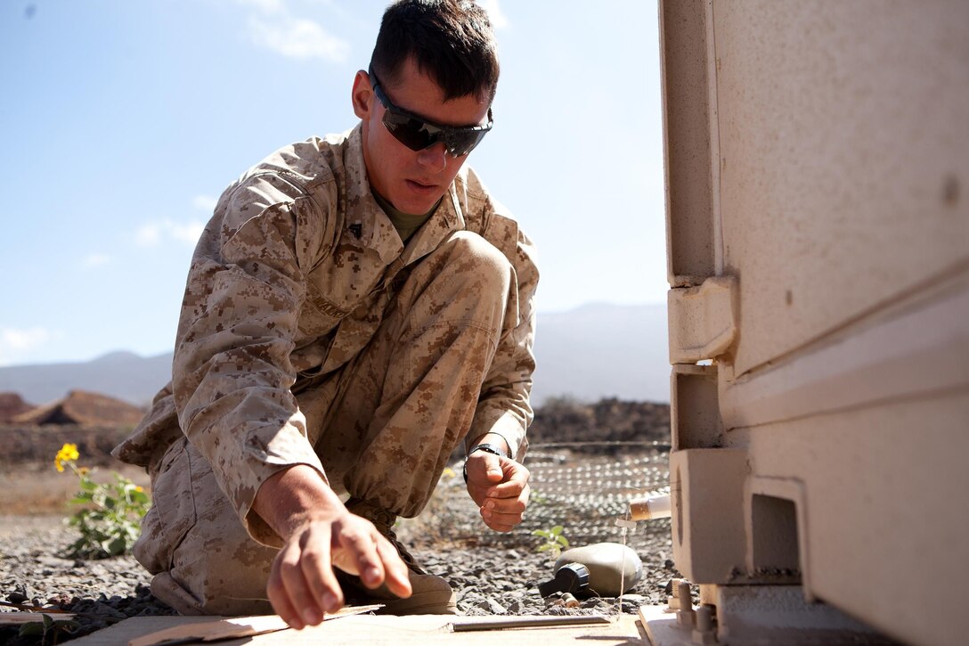 Cpl. Cody Walker, a Dinuba, Calif. native and team leader, Engineer Support Company, Combat Logistics Battalion 3 places illumination flares as simulated booby traps for Infantry Marines with 2nd Battalion, 3rd Marine Regiment, to react to during helicopter-borne assaults in Pohakuloa Training Area, Hawaii as part of Exercise Lava Viper, July 23, 2013. “We’re the jack of all trades,” said Walker on the different skills his military occupational specialty employs. (U.S. Marine Corps photo by Cpl. Matthew Callahan)