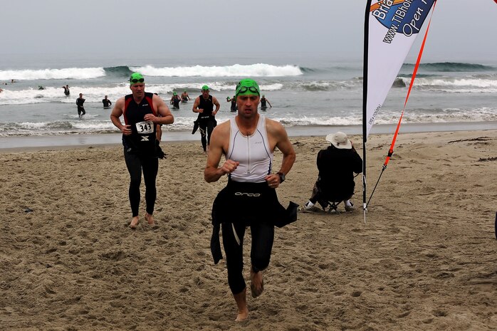 Racers run back onto the beach after the 500 meter swim portion of a triathlon during the Hardcore Race Series’ Semper Tri/Devil Dog Duathlon held at Assualt Craft Unit-5 here August 3. The Semper Tri/Devil Dog Duathlon is the first event where the race series has combined the triathlon and duathlon. Racers were also required to cycle 30 kilometers, and run 5 kilometers to complete the trial.
