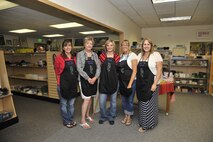 Employees and volunteers of the base thrift shop pose for a group photo at the store at Fairchild Air Force Base, Wash., Aug. 1, 2013. Volunteers are vital to the mission of the store and do everything from register duties to organization and consignment. (U.S. Air Force photo by Senior Airman Mary O'Dell/Released)