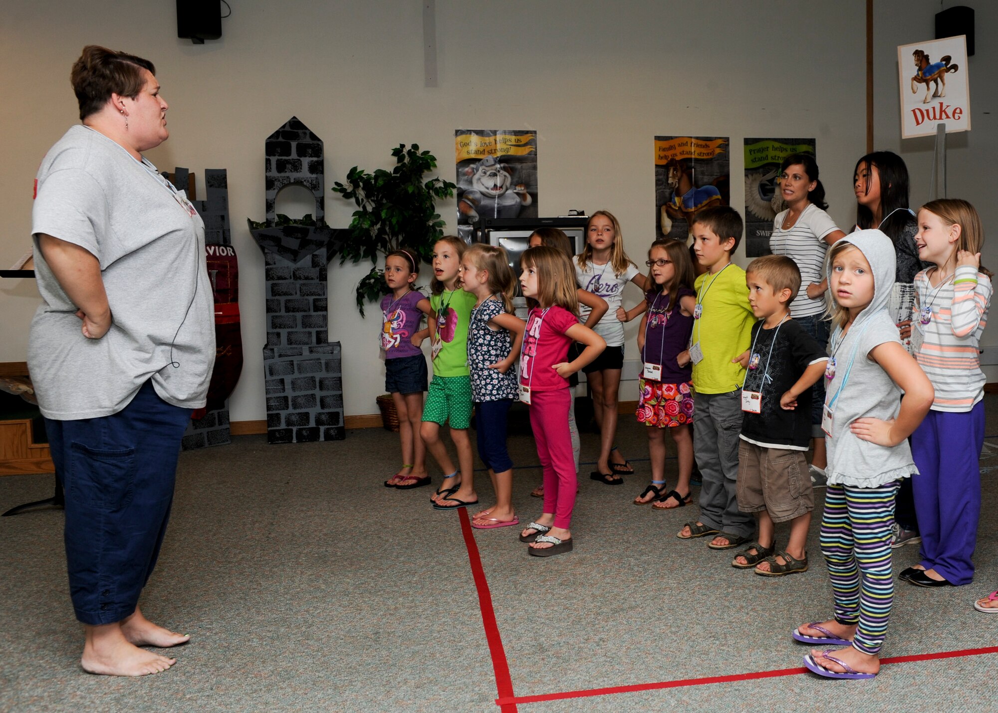 Carmen Villa, Vacation Bible School music director, leads a group of children in a worship song during Vacation Bible School at the Chapel Activities Center on Ellsworth Air Force Base, S.D., Aug. 1, 2013. The VBS consisted of children ranging from preschool to sixth grade taking part in activities throughout the week with the focus on strengthening their faiths. (U.S. Air Force photo by Airman 1st Class Anania Tekurio/Released)