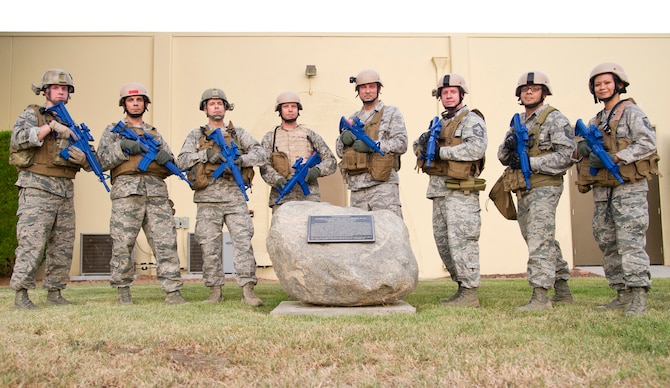 Airmen from the 4th Combat Camera Squadron pose in full tactical gear, including training weapons, after a memorial ruck march July 30 at March Air Reserve Base, Calif. The eight U.S. Air Force Reserve Command members marched in honor of U.S. Army Spc. Hilda Clayton, a fellow combat camera professional who was killed in action July 2 in Afghanistan. The 4th CTCS plans to make the memorial ruck an annual event. (U.S. Air Force photo/Staff Sgt. Jonathan Garcia) 
