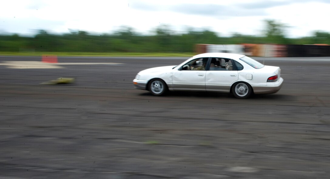 A student navigates the driving course at formidable speeds during the Combat Aviation Advisor Military Qualifications Skills Course at Eglin Range on Elgin Range, Fla., June 18, 2013.  Students of the course practiced quickly familiarizing themselves with random cars which  handle differently to mimic a real world situation while they navigated through traffic cones.  (U.S. Air Force photo by Airman 1st Class Benjamin Kim)