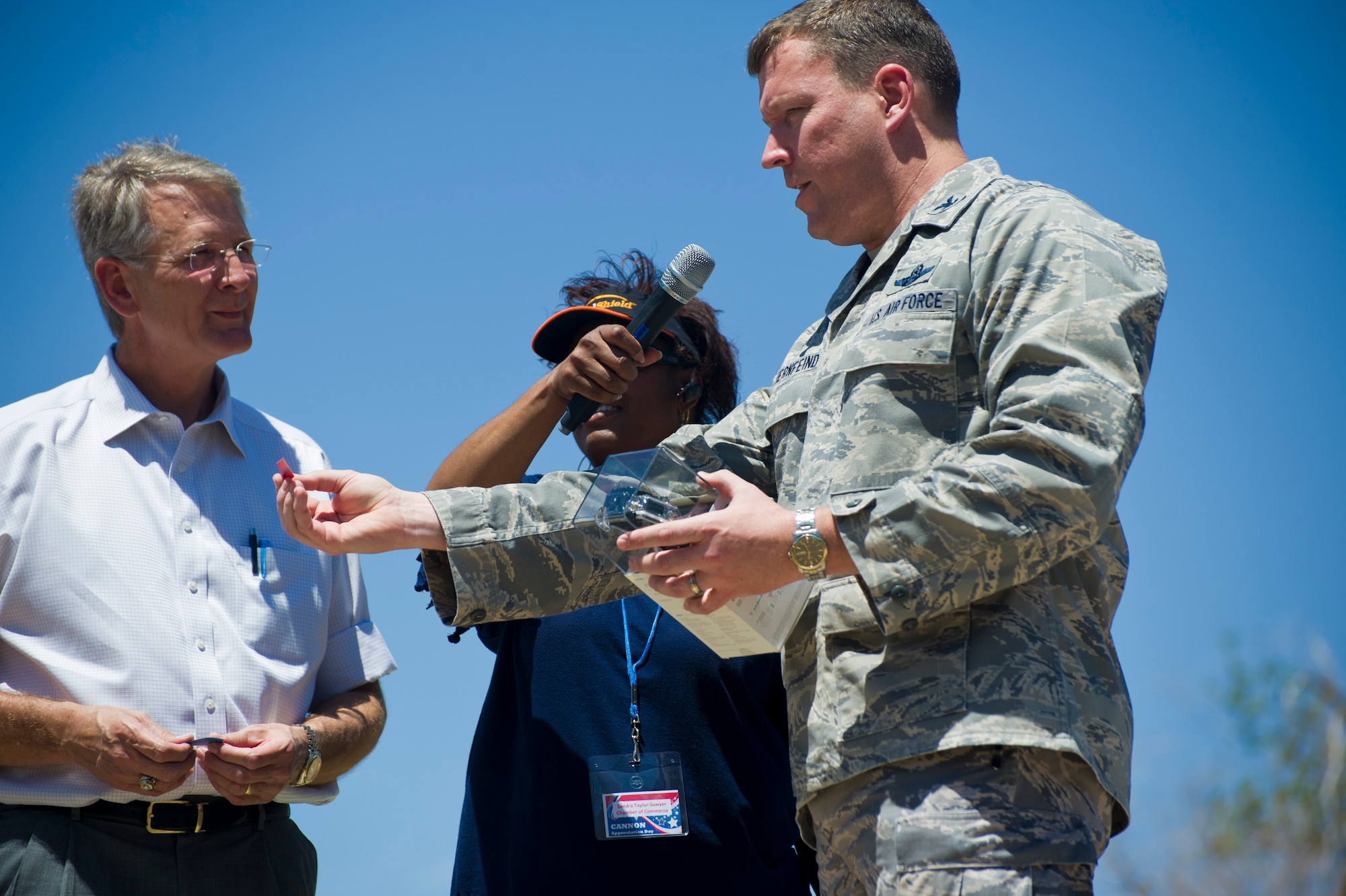 David Lundsford, mayor of Clovis N.M., Sandra Taylor-Sawyer, Clovis/Curry County Chamber of Commerce, and Col. Tony Bauernfeind, 27th Special Operations Wing commander, call out raffle ticket numbers during Cannon Appreciation Day at Cannon Air Force Base, N.M., Aug. 2, 2013. The Clovis/Curry County Chamber of Commerce, Committee of Fifty and the Clovis Industrial Development Corporation came together to sponsor the event for members of the Cannon community. (U.S. Air Force photo/by Airman 1st Class Xavier Lockley)