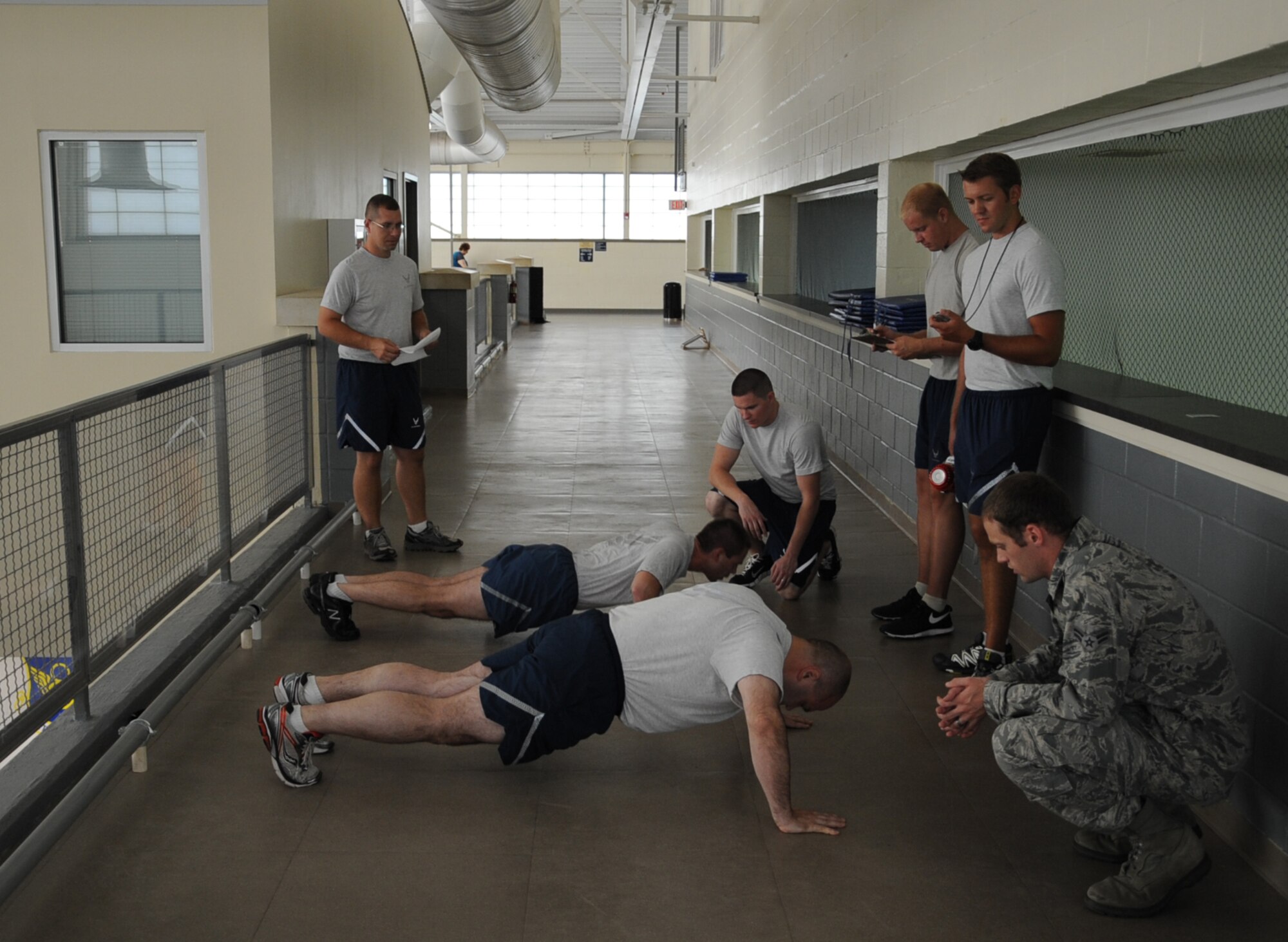 Airmen perform the push-up portion of a physical fitness test on Barksdale Air Force Base, La., Aug. 5, 2013. Airmen who achieve a score of 90 percent or higher on the test do not have to test for another year. If they score between 75 and 90 percent, they must test again in six months. Anything below 75 percent is a failure. (U.S. Air Force photo/Senior Airman Sean Martin)
