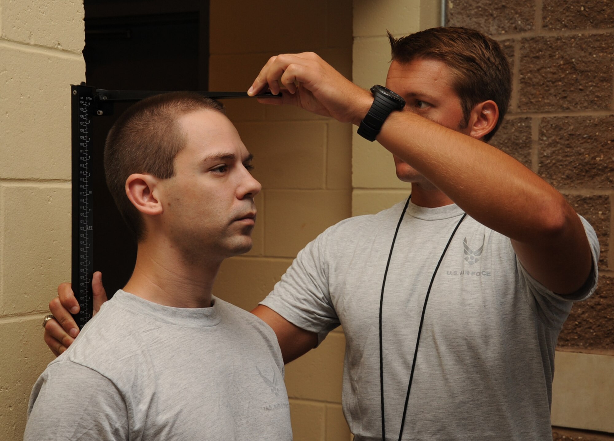 Airman 1st Class Andrew Alexander, right, 608th Air Operations Center client systems technician, measures the height of Senior Airman Joseph Trahan, 2nd Aircraft Maintenance Squadron crew chief, during a physical fitness test on Barksdale Air Force Base, La., Aug. 5, 2013. Physical Training Leaders from various squadrons are asked to assist fitness center personnel during physical fitness testing. This is done to ensure the PTLs stay current with their training and that their units are performing each component of the test correctly. (U.S. Air Force photo/Senior Airman Sean Martin)
