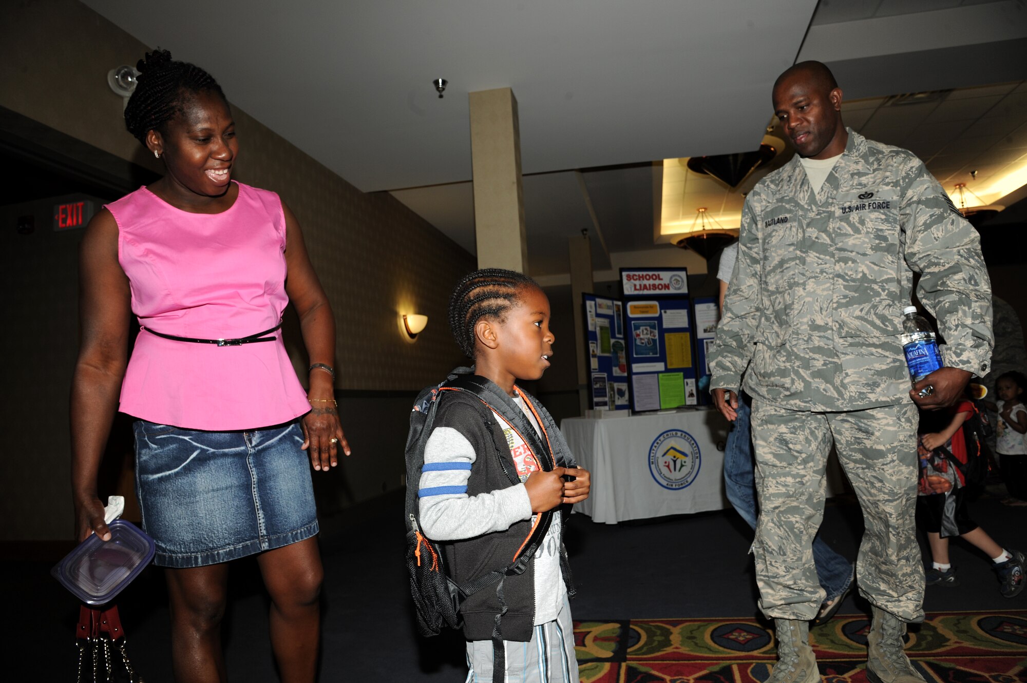 Tech. Sgt. Paul Maitland, 319th Civil Engineer Squadron, and his wife, Marcel, watch their son, Paul Jr., 4, as he tries on a new backpack at the Preschool Fair, Aug. 1, 2013, on Grand Forks Air Force Base, N.D. The School Liaison Office hosted the event to inform parents with children between the ages of 3 and 5 about the preschool options on and off-base. (U.S. Air Force photo/Senior Airman Ashley Nicole Taylor)