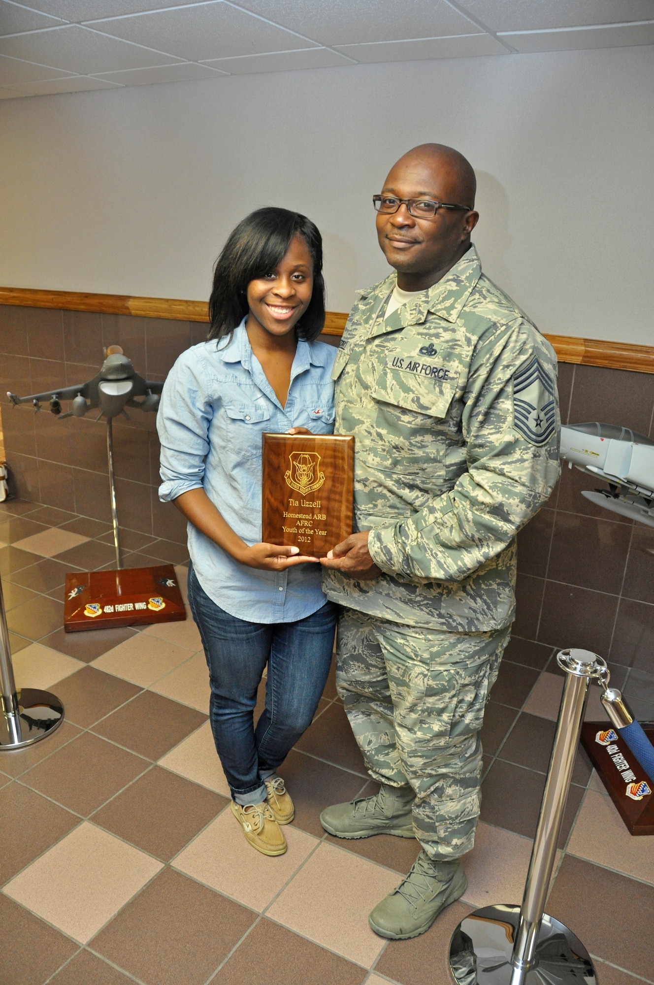 Ms. Tia Uzzell holds up her plaque for winning the 2012 Homestead Air Reserve Base Air Force Reserve Command Youth of the Year Award with her father Chief Master Sgt. Michael Uzzell, 482nd Maintenance Group Superintendent , Aug. 3. (U.S. Air Force photo/ Tech. Sgt. Lou Burton)