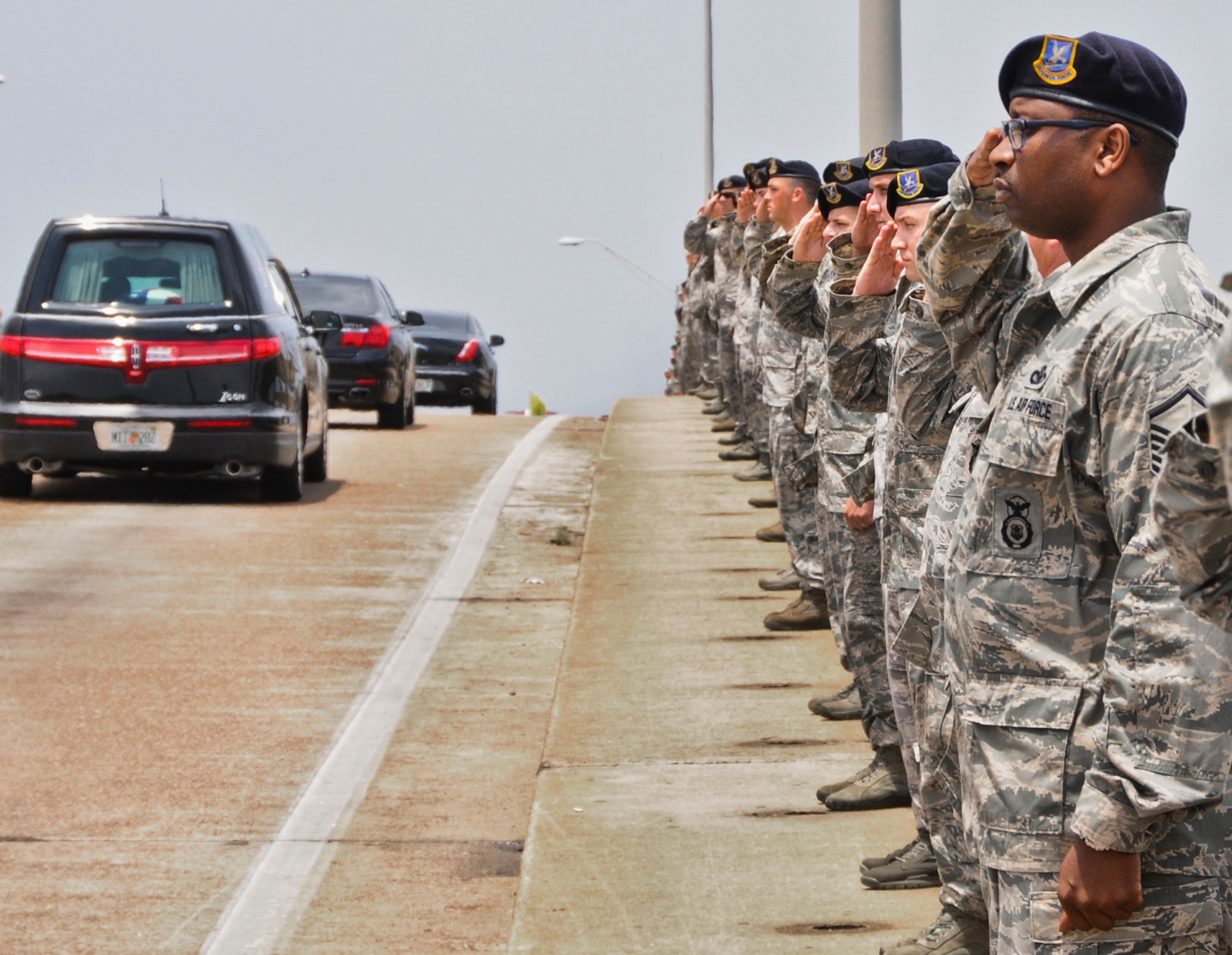 Airmen from the 96th Mission Support Group render a final salute to honor Col. George "Bud" Day, as his funeral procession passes on Brooks Bridge, Fort Walton Beach, Fla. Day, a Medal of Honor recipient and combat pilot with service in World War II, Korea and Vietnam. died July 27 at the age of 88. (Courtesy photo/Scott Jackson)