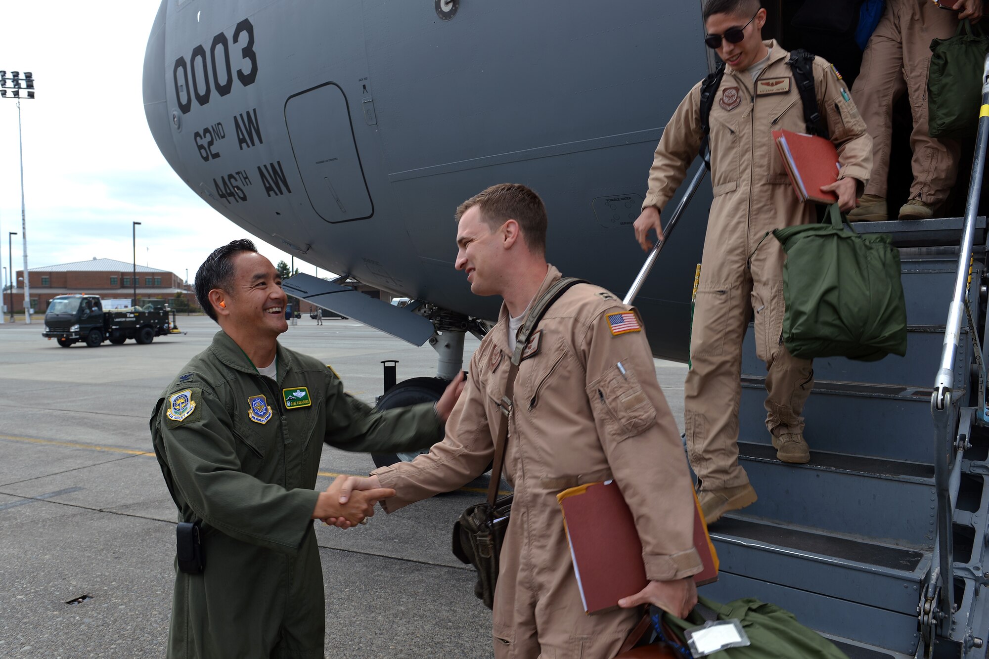 Col. David Kumashiro, 62nd Airlift wing commander, welcomes home Airmen, Aug. 3, 2013, from the 7th Airlift Squadron at Joint Base Lewis-McChord, Wash., after their return from a 60-day deployment. The deployment of the 62nd AW's four active duty flying squadrons allow Air Mobility Command to consistently position assets closer to the action. (U.S. Air Force photo/Airman 1st Class Jacob Jimenez)