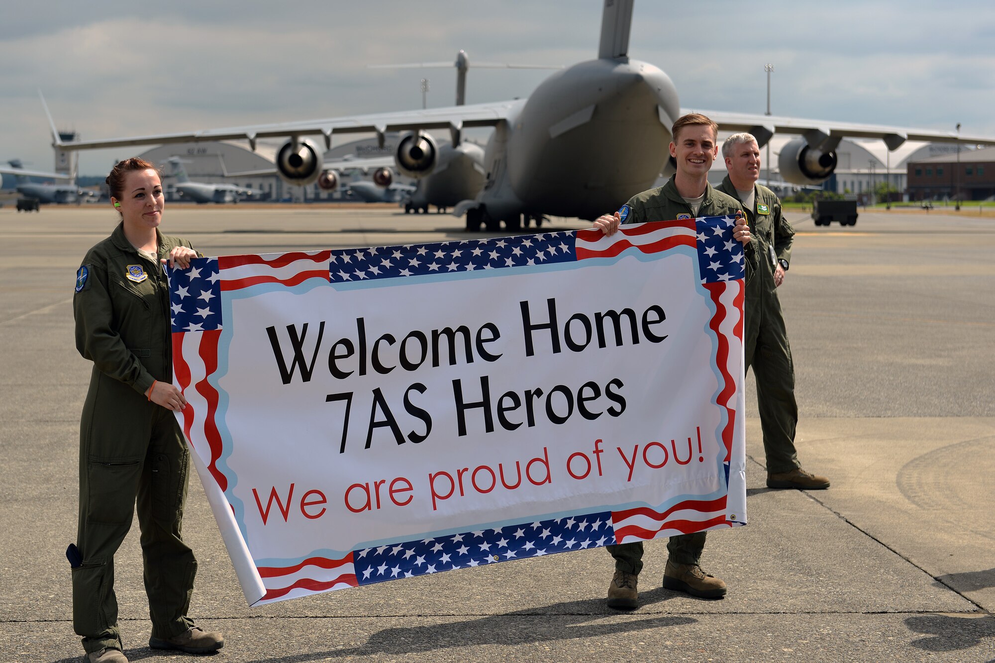 Airman 1st Class Christine Briggs and Jeramey Reamer, 7th Airlift Squadron loadmasters, wait at Joint Base Lewis-McChord, Wash., Aug. 3, 2013, for the arrival of members from their squadron returning from a 60-day deployment. The 62nd Airlift Wing's four active duty flying squadrons share responsibility for the deployed squadron and rotate operating the 817th Expeditionary Airlift Squadron continuously. (U.S. Air Force photo/Airman 1st Class Jacob Jimenez) 