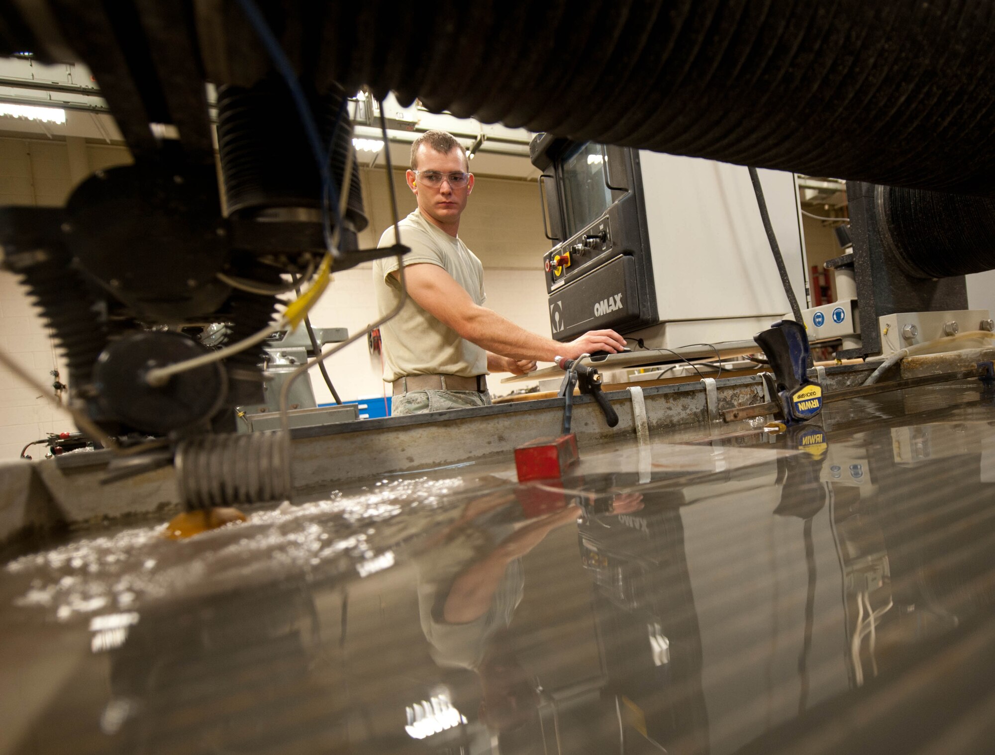 Airman 1st Class Tyler Jones, 28th Maintenance Squadron aircraft metals technician, uses a water jet to heat a metal block and fabricate an aircraft nose bracket at Ellsworth Air Force Base, S.D., July 30, 2013. Aircraft metals technicians are part of the 28th MXS squadron which is responsible for all off-equipment maintenance and heavy repairs, maintaining 660 pieces of aerospace ground equipment and supporting 28 combat-coded-B-1 bomber aircraft. (U.S. Air Force photo by Airman 1st Class Zachary Hada/Released)