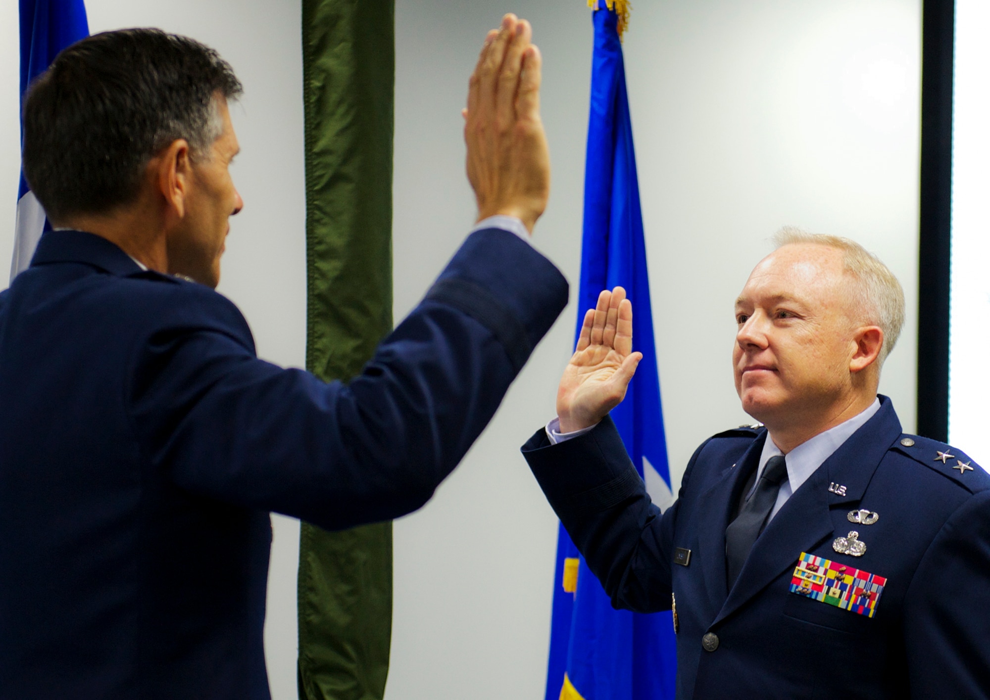 Newly-ranked Maj. Gen. Scott Jansson, the Air Force Program Executive Officer for Weapons, Armament Directorate, receives the oath of office from by Lt. Gen. C.D. Moore II, commander, Air Force Life Cycle Management Center, during his two-star pin-on ceremony Aug. 2 at Eglin Air Force Base, Fla. (U.S. Air Force photo/Sara Vidoni)