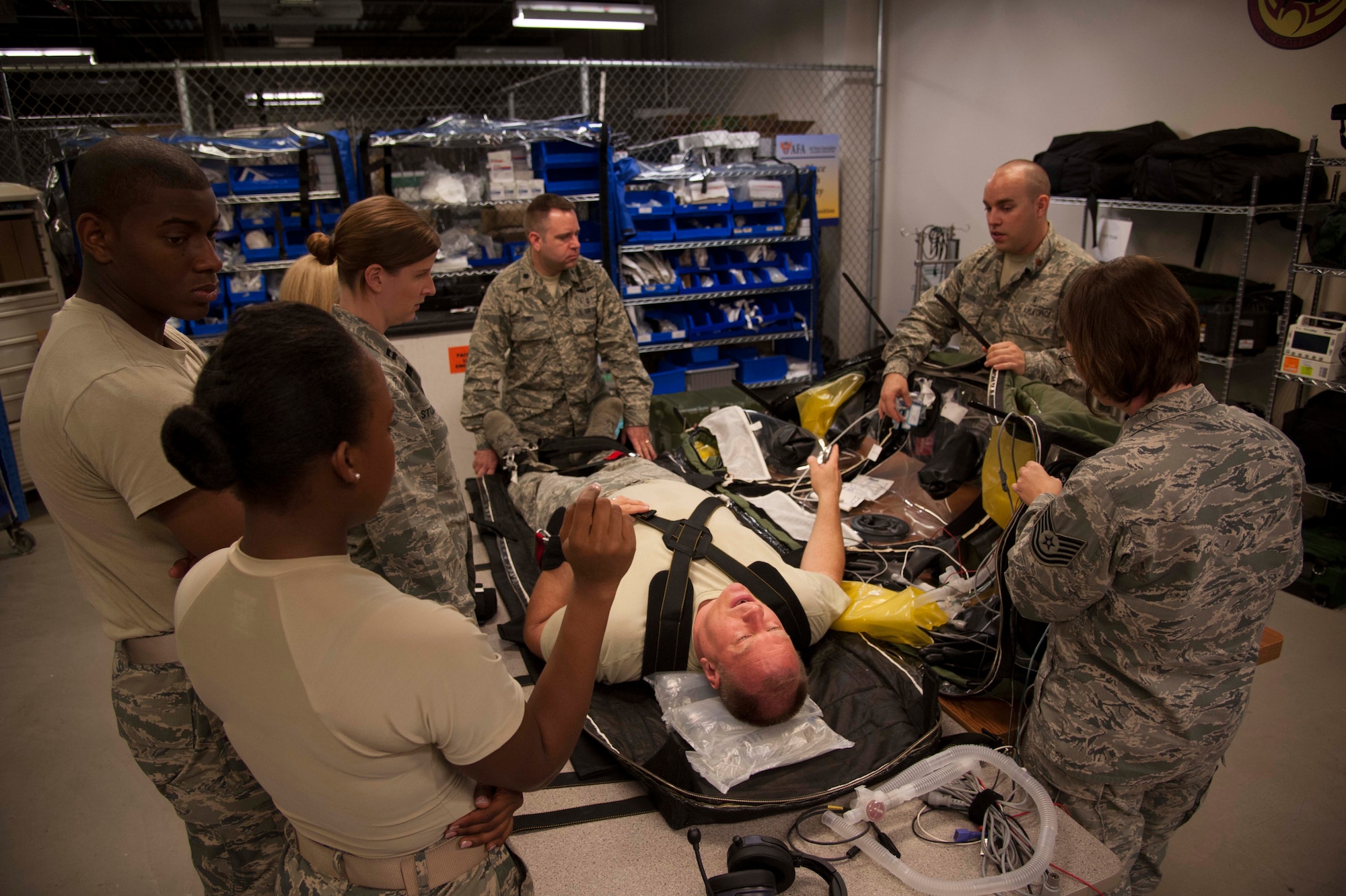 (Center) Maj. William Moore, 59th Medical Wing Critical Care Air Transport Team Pilot Unit Coordinator, showcases a Patient Isolation Unit (PIU) during CCATT training at Joint Base San Antonio-Lackland, May, 23, 2013. The (PIU) is a temporary, single-use, portable structure that is designed to fully contain and transport a patient and prevent contamination between the patient, the external environment and the caregivers. The 59th Medical Wing CCAT teams currently have the only PIU mission in the entire Department of Defense. (U.S. Air Force photo/Staff Sgt. Corey Hook)