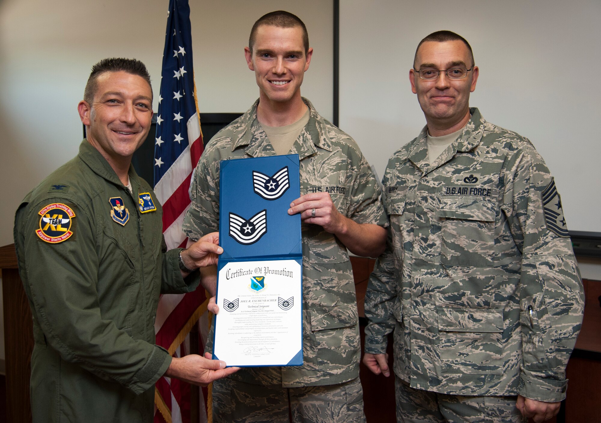 Newly promoted Tech. Sgt. Joel R. Eschenbacher, 47th Force Support Squadron manpower and organizations analysis technician, poses with Col. Brian Hastings, 47th Flying Training Wing commander, and Chief Master Sgt. Gary Berry, 47th FTW command chief, after being presented technical sergeant rank through the Air Force's Stripes for Exceptional Performers program here July 31, 2013. The STEP program is a highly visible promotion recognition program used by commanders at all levels to recognize the outstanding contributions and accomplishments of senior airmen, staff sergeants and technical sergeants. (U.S. Air Force photo/Senior Airman John D. Partlow)