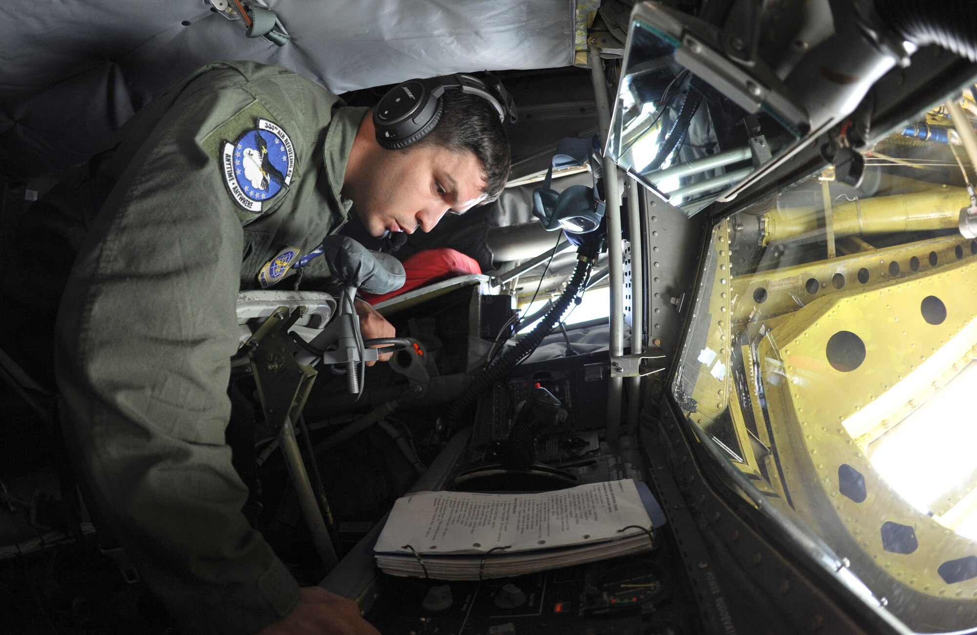 Airman 1st Class Kevin Berneburg, 334th Air Refueling Squadron boom operator, references his post air refueling checklist after refueling a B-2 Spirit August 1, 2013, over Midwestern skies. This is the first time Berneburg has refueled a Spirit. (U.S. Air Force Photo/Airman 1st Class John Linzmeier)