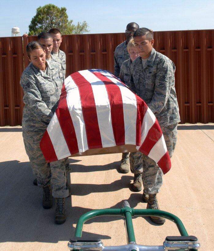 Airmen assigned to the 7th Bomb Wing Honor Guard, pallbearer a casket during training week, Aug. 2, 2013, at the honor guard building on Dyess Air Force Base, Texas. Airmen spend three months with the honor guard, traveling around Texas to perform ceremonial duties for deceased service members. Dyess covers 34,000 square miles, 38 counties and perform more than 200 funerals a month. During the funerals the members pallbearer the casket, perform a flag fold, a three-man gun salute, play taps and present the flag and three shell casings to the next-of-kin. (U.S. Air Force photo by Senior Airman Shannon Hall/Released)