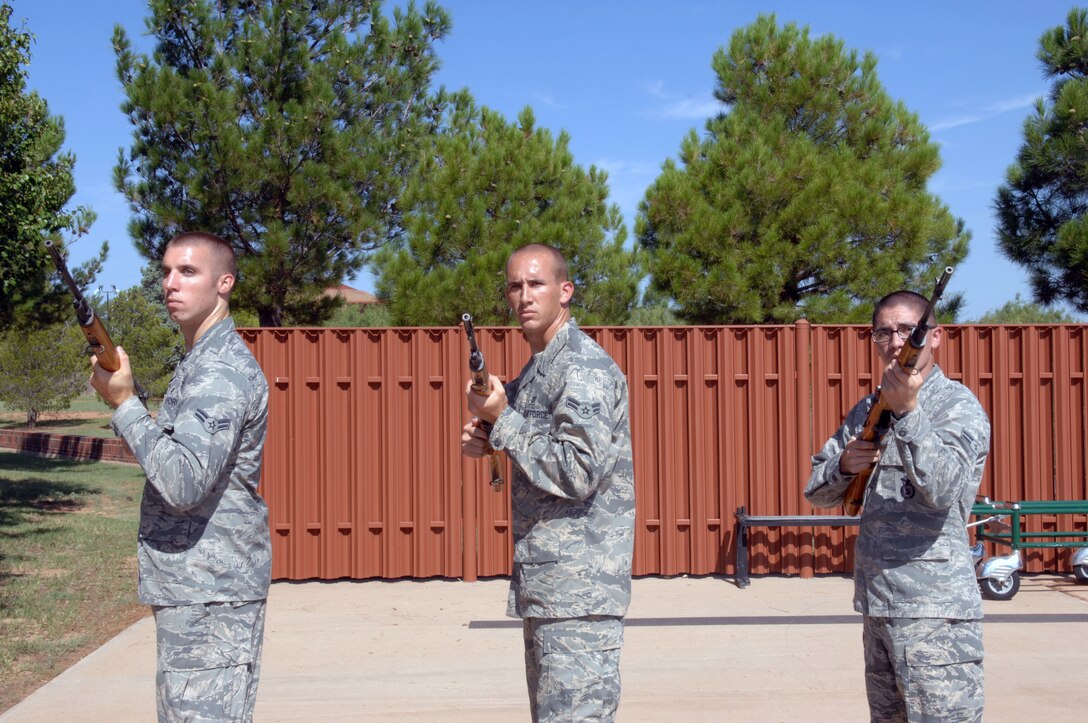 Airmen assigned to the 7th Bomb Wing Honor Guard, practice a three-man gun salute during training week, Aug. 2, 2013, at the honor guard building on Dyess Air Force Base, Texas. Airmen spend three months with the honor guard, traveling around Texas to perform ceremonial duties for deceased service members. Dyess covers 34,000 square miles, 38 counties and perform more than 200 funerals a month. During the funerals the members pallbearer the casket, perform a flag fold, a three-man gun salute, play taps and present the flag and three shell casings to the next-of-kin. (U.S. Air Force photo by Senior Airman Shannon Hall/Released)