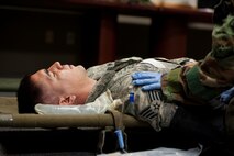 Staff Sgt. Matthew Orozco, 8th Aircraft Maintenance Squadron exercise “victim,” is treated by 8th Medical Group medics during an exercise at Kunsan Air Base, Republic of Korea, August 5, 2013. Medics from the 8th MDG responded to an simulated illness spreading via contaminated food. (U.S. Air Force photo by Senior Airman Armando A. Schwier-Morales/ Released)