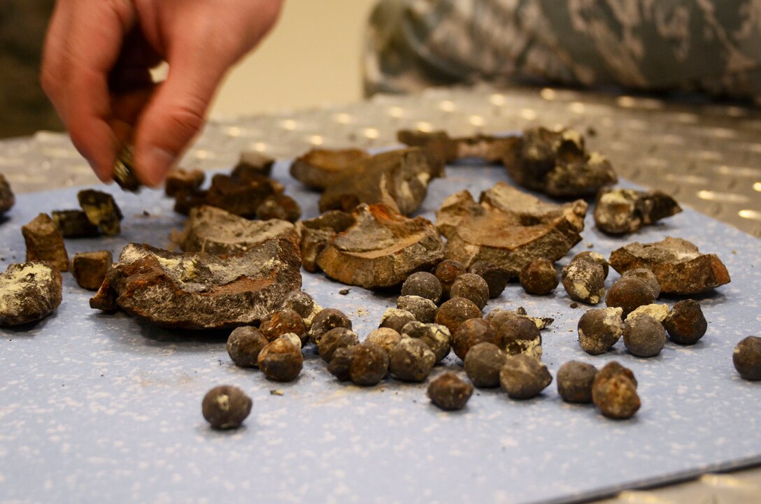Members of the 94th Explosive Ordnance Flight, Dobbins Air Reserve Base, Ga., examine fragments of a civil war era cannon ball at the base Aug 2. The cannon ball was detonated and disposed of by the Dobbins EOD team after being discovered near Centennial Park, downtown Atlanta July 18. (U.S. Air Force photo/Don Peek)