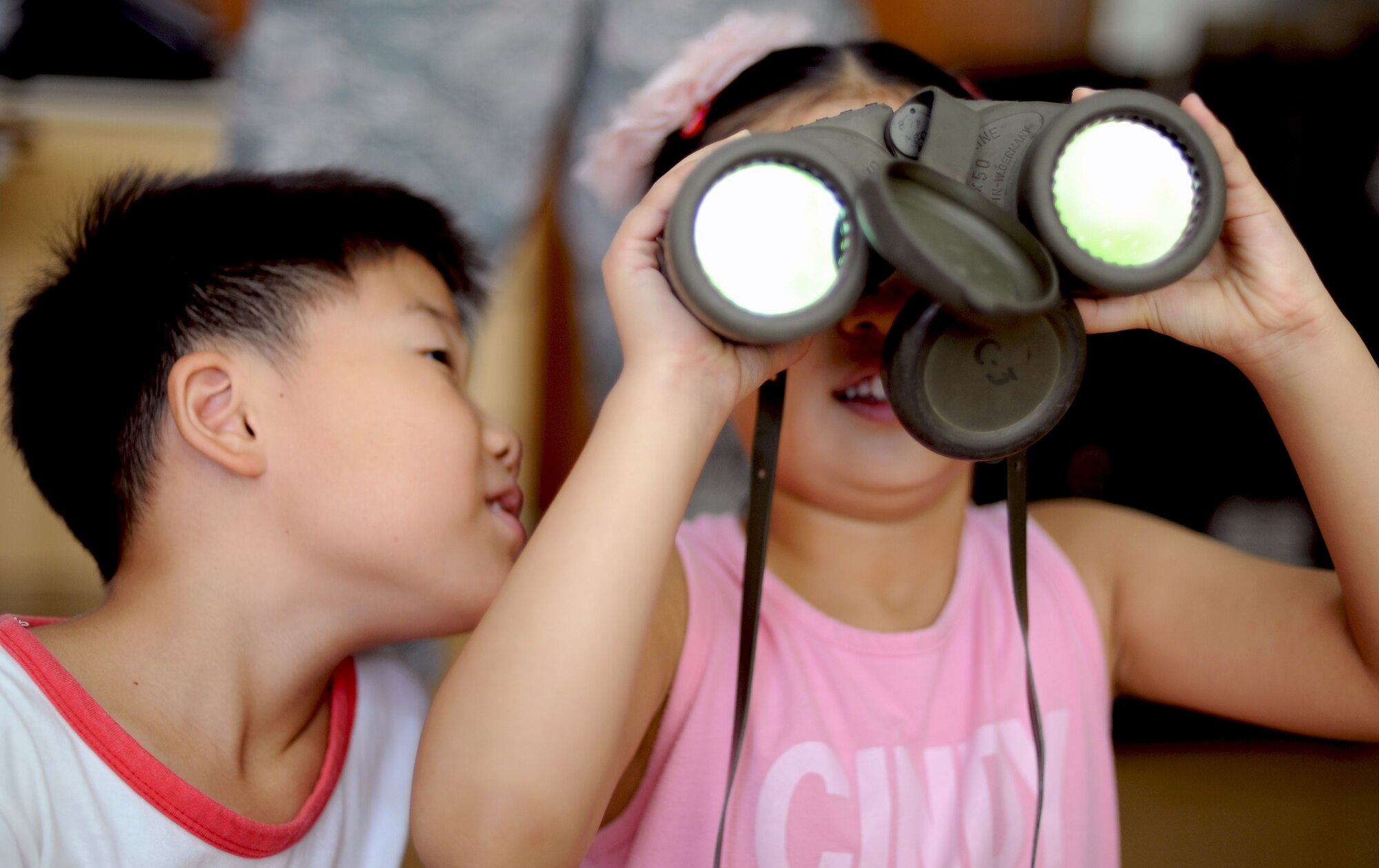 A child from the Kyesung-Elementary School in Pyeongtaek-si, Gyeonggi-do, Republic of Korea, looks through binoculars during an educational presentation by Airmen from Detachment 2, 607th Weather Squadron located at Camp Humphreys, ROK, Aug. 1, 2013. The two Airmen from the weather squadron spent an entire morning with the children, teaching them about what they do as weather forecasters for the U.S. Air Force and helping them with their English. (U.S. Air Force photo/Staff Sgt. Sara Csurilla)  