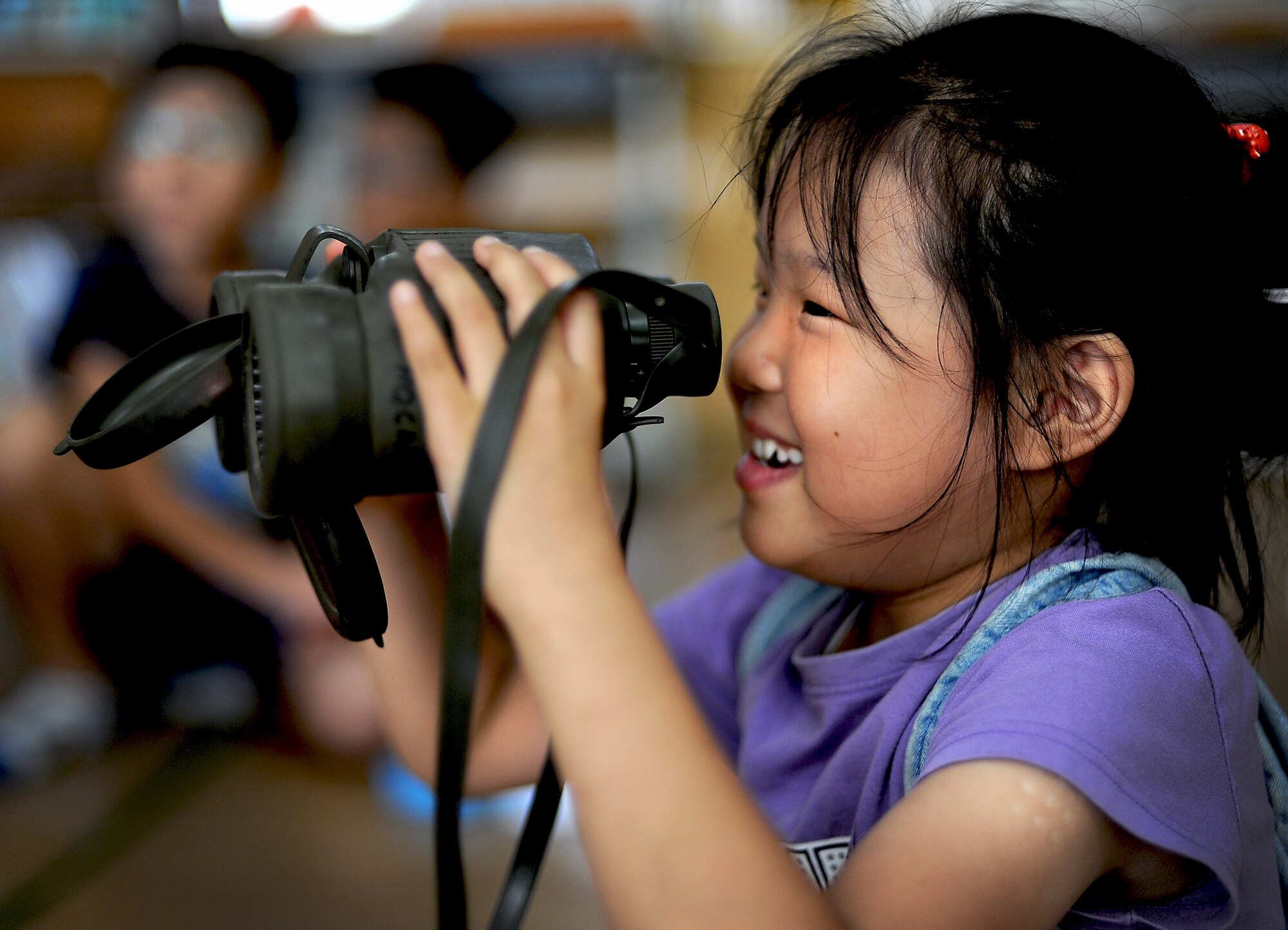 A child from the Kyesung-Elementary School in Pyeongtaek-si, Gyeonggi-do, Republic of Korea, looks through binoculars during an educational presentation by Airmen from Detachment 2, 607th Weather Squadron located at Camp Humphreys, ROK, Aug. 1, 2013. The two Airmen from the weather squadron spent an entire morning with the children, teaching them about what they do as weather forecasters for the U.S. Air Force and helping them with their English. (U.S. Air Force photo/Staff Sgt. Sara Csurilla)  