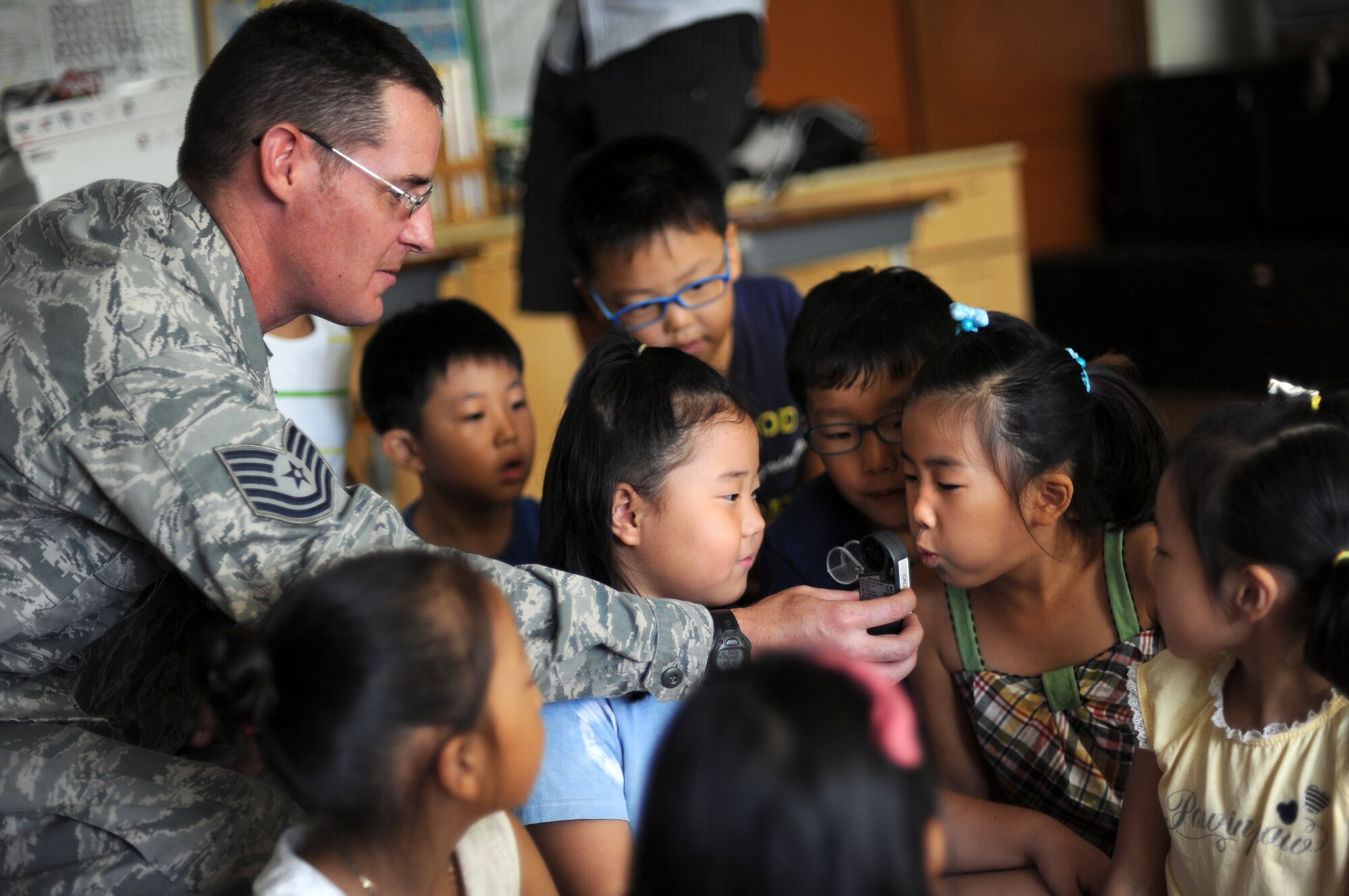 Tech. Sgt. Sean Reynolds, battlefield weather forecaster with Detachment 2, 607th Weather Squadron located at Camp Humphreys, Republic of Korea, lets children test a portable wind and weather reader at the Kyesung-Elementary School in Pyeongtaek-si, Gyeonggi-do, Republic of Korea, Aug. 1, 2013. Reynolds visited the school to teach the children about his job as a U.S. Air Force weather forecaster and to help them better learn English. U.S service members throughout the peninsula visit with members of the local ROK community to help better understand each other’s cultures and enhance international relationships. (U.S. Air Force photo/Staff Sgt. Sara Csurilla)  