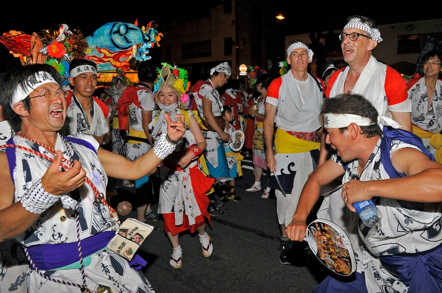 Members of Misawa Air Base leadership participate in the Aomori Nebuta Festival parade with Japanese nationals at Aomori City, Japan, Aug. 3, 2013. During the parade, hundreds of dancers surround floats and dance to the tune of flutes and the beat of drums. (U.S. Air Force photo by Airman 1st Class Zachary Kee)