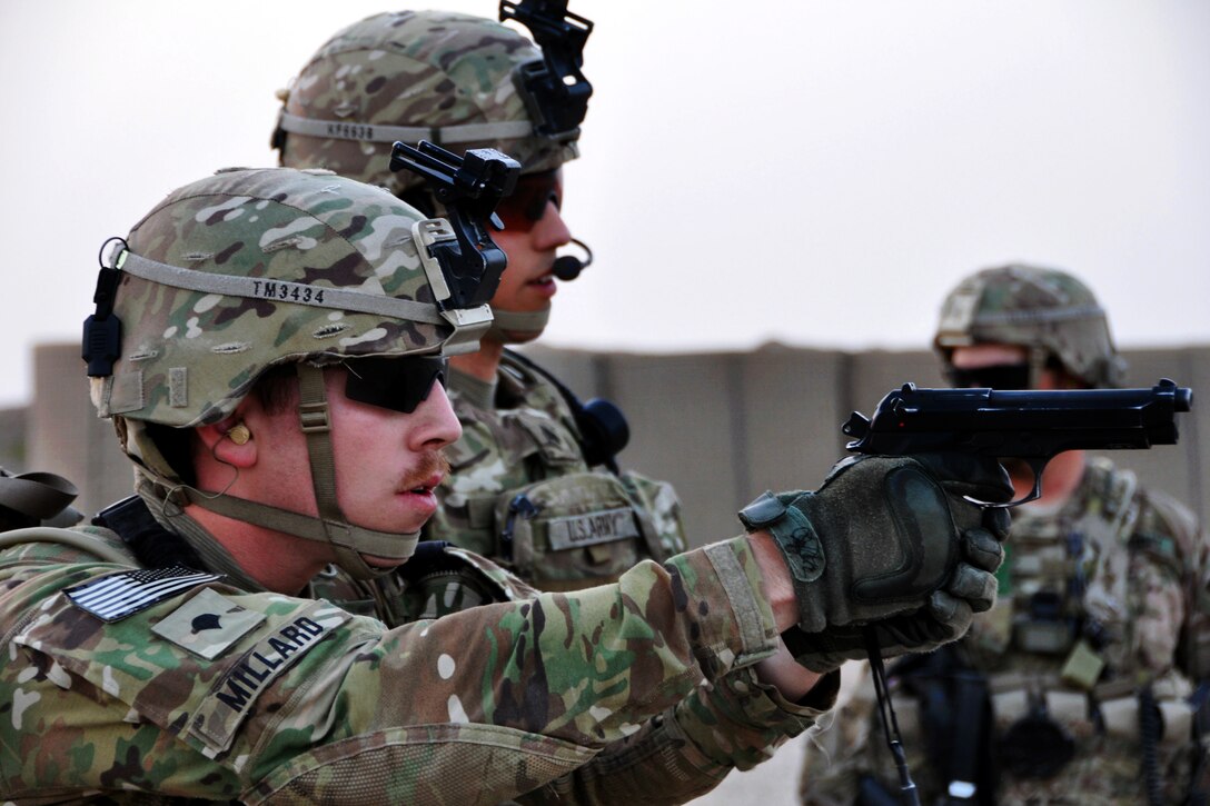 U.S. Army Spc. Travis Millard, left, fires an M9 pistol while U.S. Army Sgt. Kenneth Fellows, center, observes during a small arms range training exercise on Forward Operating Base Farah, Afghanistan, July 31, 2013. Millard and Fellows are assigned to Provincial Reconstruction Team Farah.