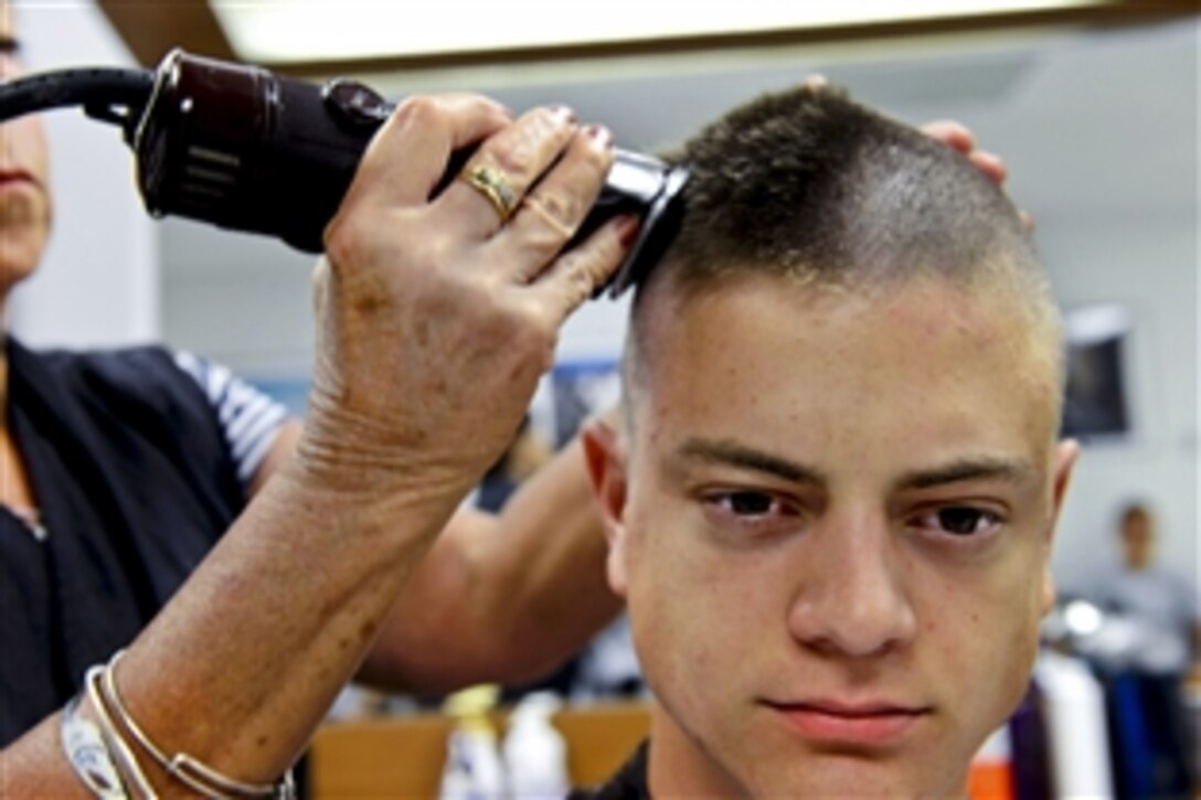 A new recruit gets a hair cut at the Coast Guard Training Center Cape May, N.J., July 30, 2013. Procedures require recruits to have a shaved head to promote uniformity and cohesion among the newly formed company.