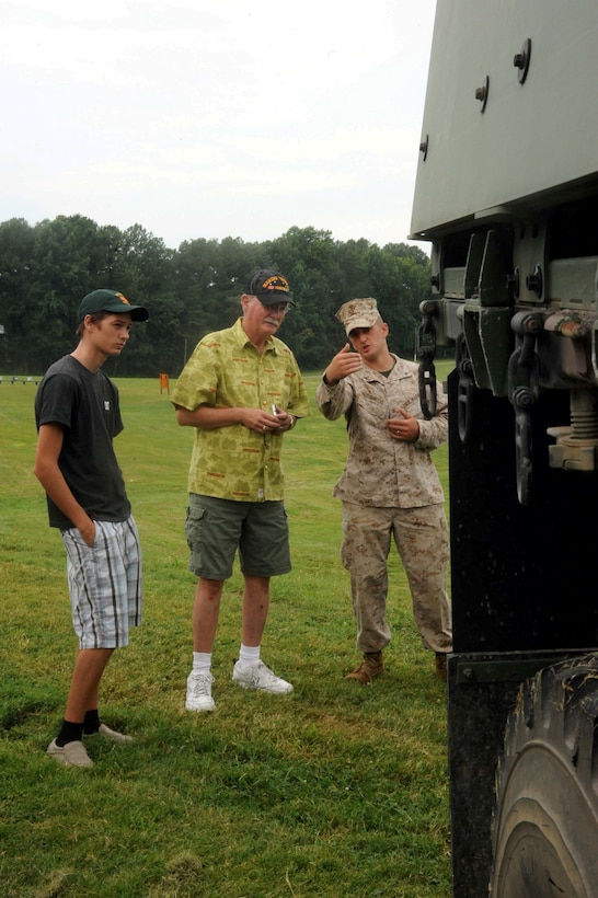 Lance Cpl. Al Dinuccio, motor vehicle operator, talks to guests at the Sergeant Major of the Marine Corps Picnic aboard Marine Corps Base Quantico on August 3, 2013. Over 200 retired and active duty Marines and family members attended the event.