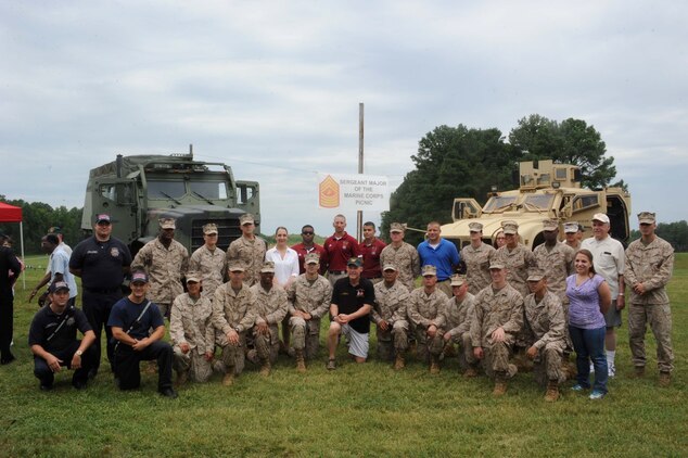 Sgt. Major Micheal Barrett, sergeant major of the Marine Corps, poses for a photo with a group during the Sergeant Major Picnic aboard Marine Corps Base Quantico on Aug. 3, 2013. Several units including The Basic School, the Single Marine Program, the Provost Marshal’s Office and the Marine Corps Martial Arts Center for Excellence provided displays and demonstrations at the event.