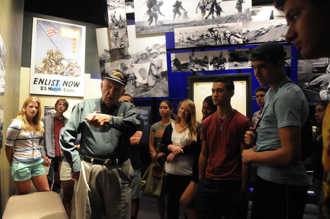 Iwo Jima veteran and National Museum of the Marine Corps docent Frank Matthews shows a group of high school students the place on a map of the island of Iwo Jima where his unit landed and then fought its way north for two hours under fire. 