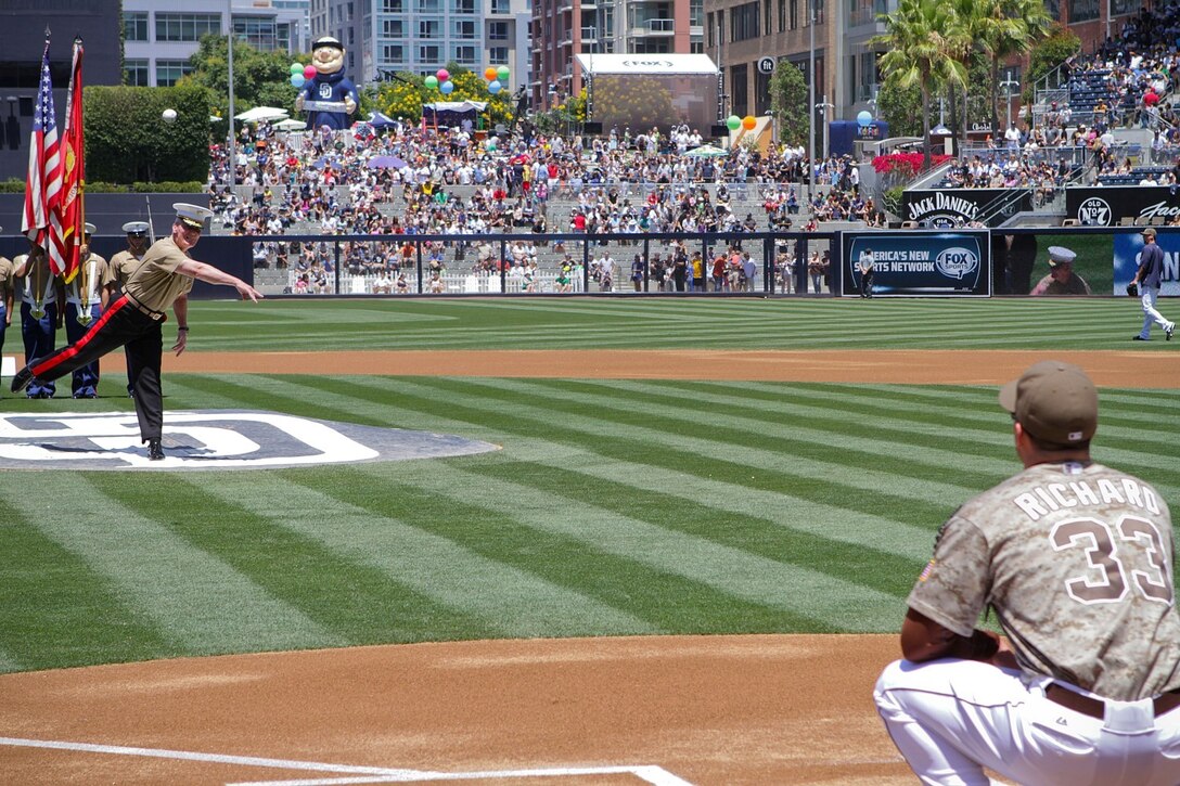 Lieutenant Gen. John Toolan Jr., the commanding general of I Marine Expeditionary Force, delivers the ceremonial first pitch to San Diego Padres pitch Clayton Richard during the Padres vs. New York Yankees game here, Aug. 4, 2013. Baseball fans gave a standing ovation to Marines of 1st Marine Logistics Group, Marine drill instructors from Marine Corps Recruit Depot San Diego, and sailors of the USS Carl Vinson who lined the baseball diamond just before the start of the game.