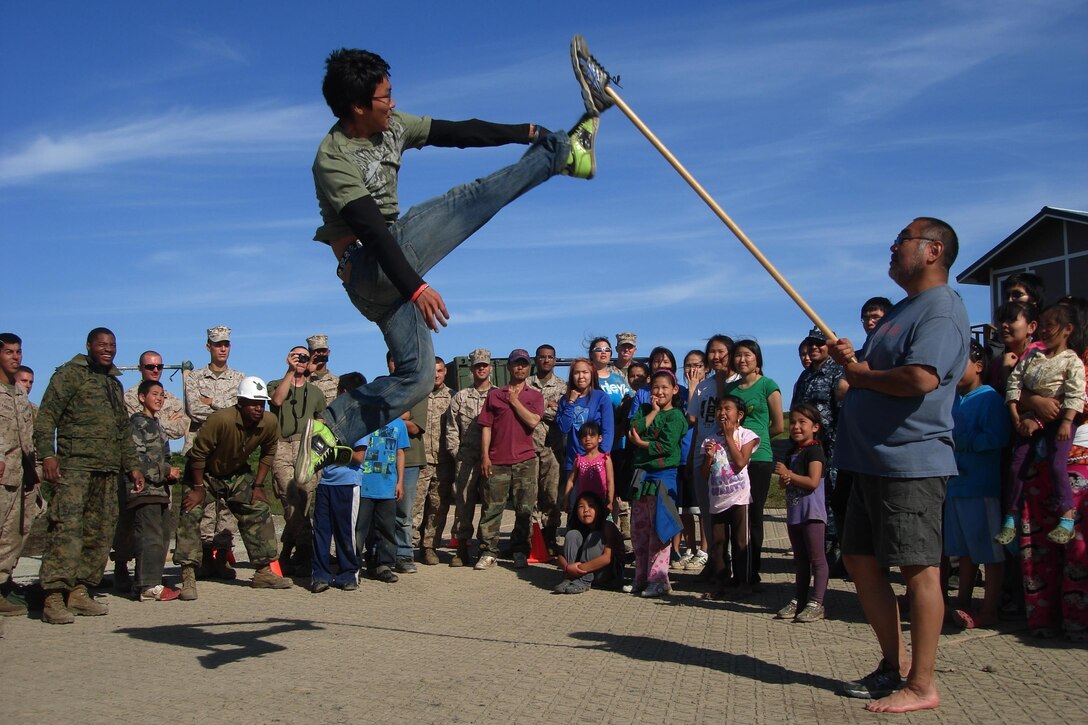 Marines of 6th Engineer Support Battalion, 4th Marine Logistics Group, sailors from Navy Reserve Forces Command and villagers of Newtok, Alaska, watch as a young villager performs an agility challenge during a traditional native-Alaskan potluck upon the conclusion of the Innovative Readiness Training Mertarvik mission, July 28. More than 100 residents of Newtok made the nine-mile boat trip to Mertarvik with many native-Alaskan foods including several varieties of fresh and dried fish, dried seal meat, aged walrus meat, moose and several different kinds of pastries, to show their gratitude and bid farewell to the participating service members. IRT Mertarvik was a Marine-led, five-year, ongoing, joint-service, training opportunity for Reserve components of all branches of the U.S. military to hone their humanitarian skills, community relations and austere-condition operation capabilities, while supporting the relocation of a local Alaskan people of Newtok. (U.S. Marine Corps photo by Capt. Chad Hailey)