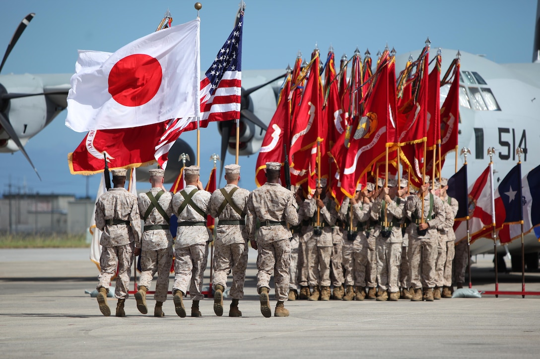 The Color Guard with 1st Marine Aircraft Wing (1st Maw) units, March on the Colors during the 1st MAW Commanding General Change of Command ceremony held on the Marine Corps Air Station Futenma flight line, Okinawa, Japan, July 9, 2013. The Change of Command ceremony represents the changing of authority between outgoing Maj. Gen. Christopher S. Owens and incoming Brig. Gen. Steven R. Rudder. (U.S. Marine Corps photo by Lance Cpl. Jeraco Jenkins MCIPAC Combat Camera/Released)