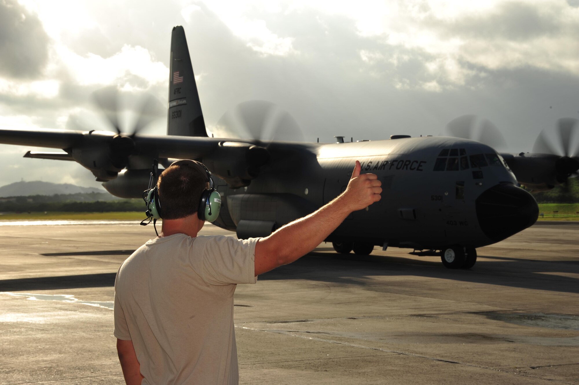 Tech. Sgt. James Piskorz, 403rd Maintenance Squadron crew chief, signals the pilots of the WC-130J that they are cleared to proceed onto the taxiway after their flight into the remnants of Dorian July 28, 2013. The 53rd Weather Reconnaissance Squadron aircrew flew through the tropical wave to gather storm data for analysis by the National Hurricane Center to help determine if Dorian was dissipating or gathering strength. Hurricane Hunter aircrews and other 403rd Wing members deploy to several locations in the United States and Pacific and Atlantic Oceans to fly storm missions during the hurricane season, which officially starts June 1 and ends November 30 each year. (U.S. Air Force photo/Tech. Sgt. Ryan Labadens)