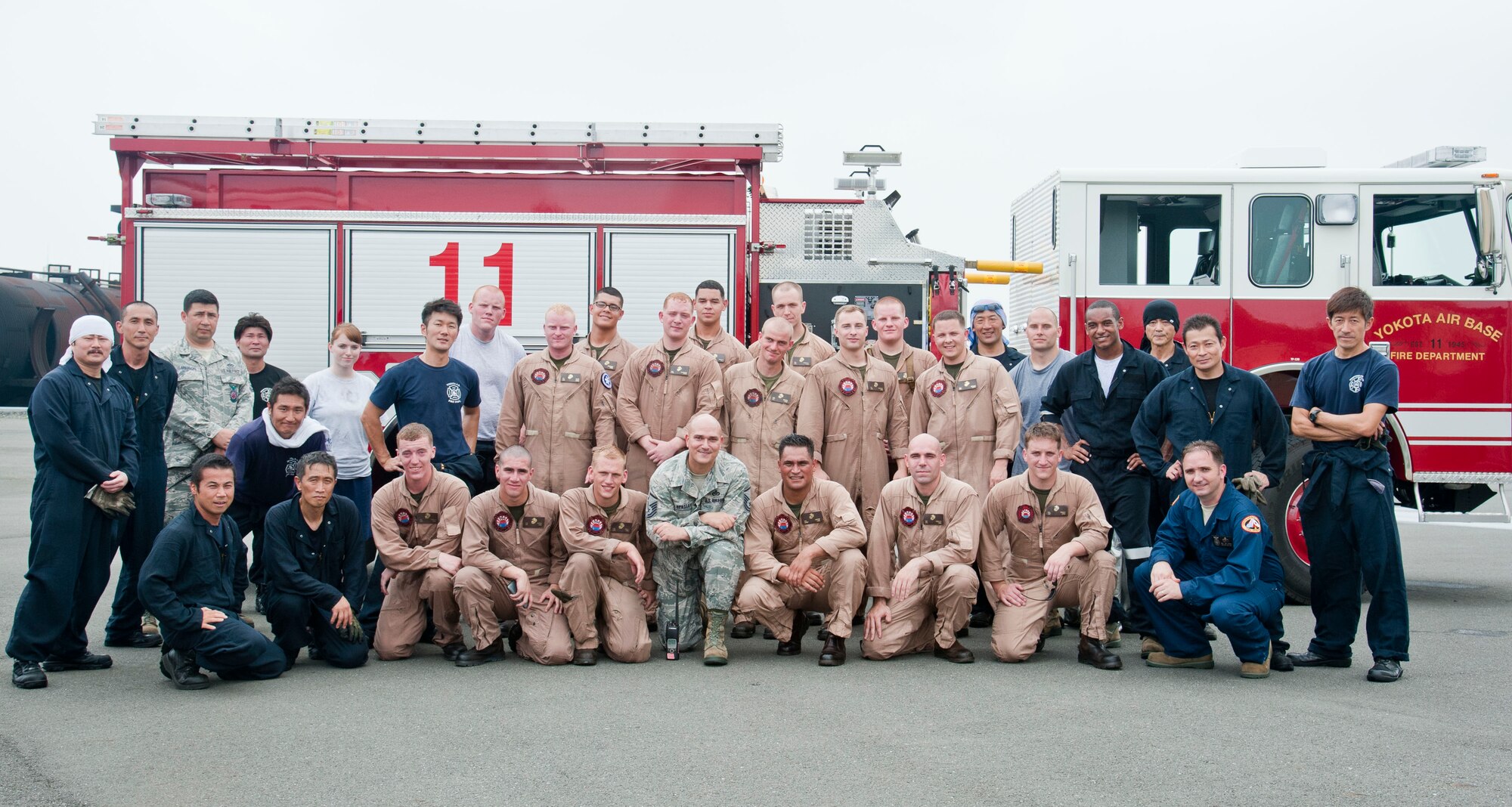 YOKOTA AIR BASE, Japan – Yokota Air Base and Marine Corps Air Station Iwakuni firefighters pose for a group photo after completing flashover training at Yokota Air Base, Japan, July 30, 2013.  “We got to train on a situation unique to us over in Iwakuni and had a chance to foster high morale with our fellow firefighters.  All in all I’d say this was a mission complete for our guys,” said Gunnery Sgt. Nathan Lanham, the Aircraft Rescue Firefighter section leader.  (U.S. Air Force photo by Airman 1st Class Soo C. Kim)
