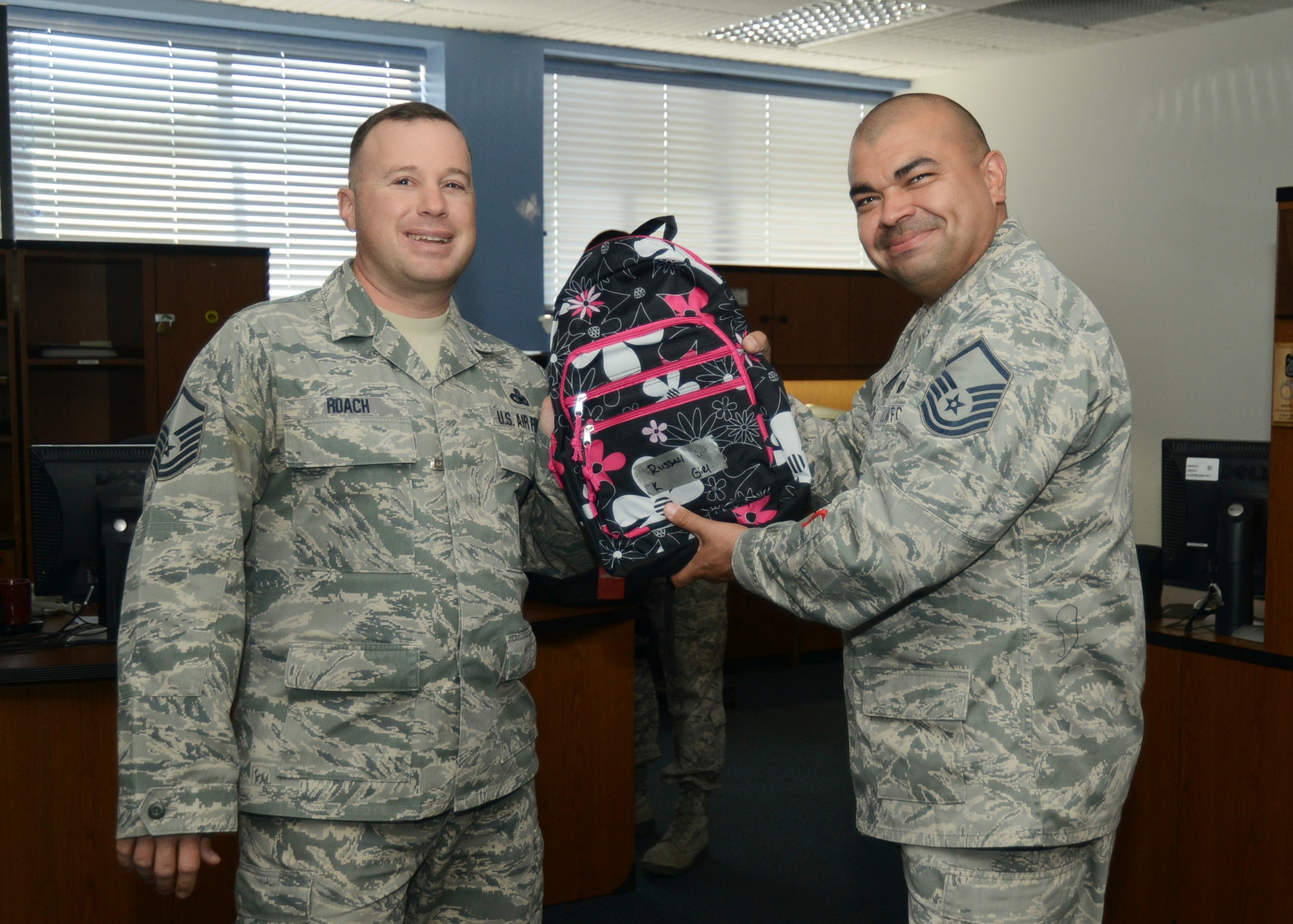 Master Sgt. Chris Roach, 412th Security Forces Squadron (left) receives a backpack filled with school supplies from Master Sgt. Richard Garcia, 412th SFS (right). The Edwards Enlisted Spouses Club and First Sergeants Council helped fill 175 backpacks with school supplies Aug. 6. The backpacks were then donated to those Airmen with school-age children along with the local community. (U.S. Air Force photo by Rebecca Amber)
