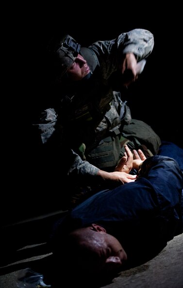 KUNSAN AIR BASE, Republic of Korea – Airman 1st Class Anthony Kelly, 8th Security Forces Squadron exercise mobile reserve member, handcuffs an opposition forces agent Aug. 7, 2013. Kelly, along with a team of security forces Airmen, responded to a simulated attack by opposition forces. The scenario illustrated the Wolf Pack’s ability to defend the base. (U.S. Air Force photo by Senior Airman Armando A. Schwier-Morales/Released)  