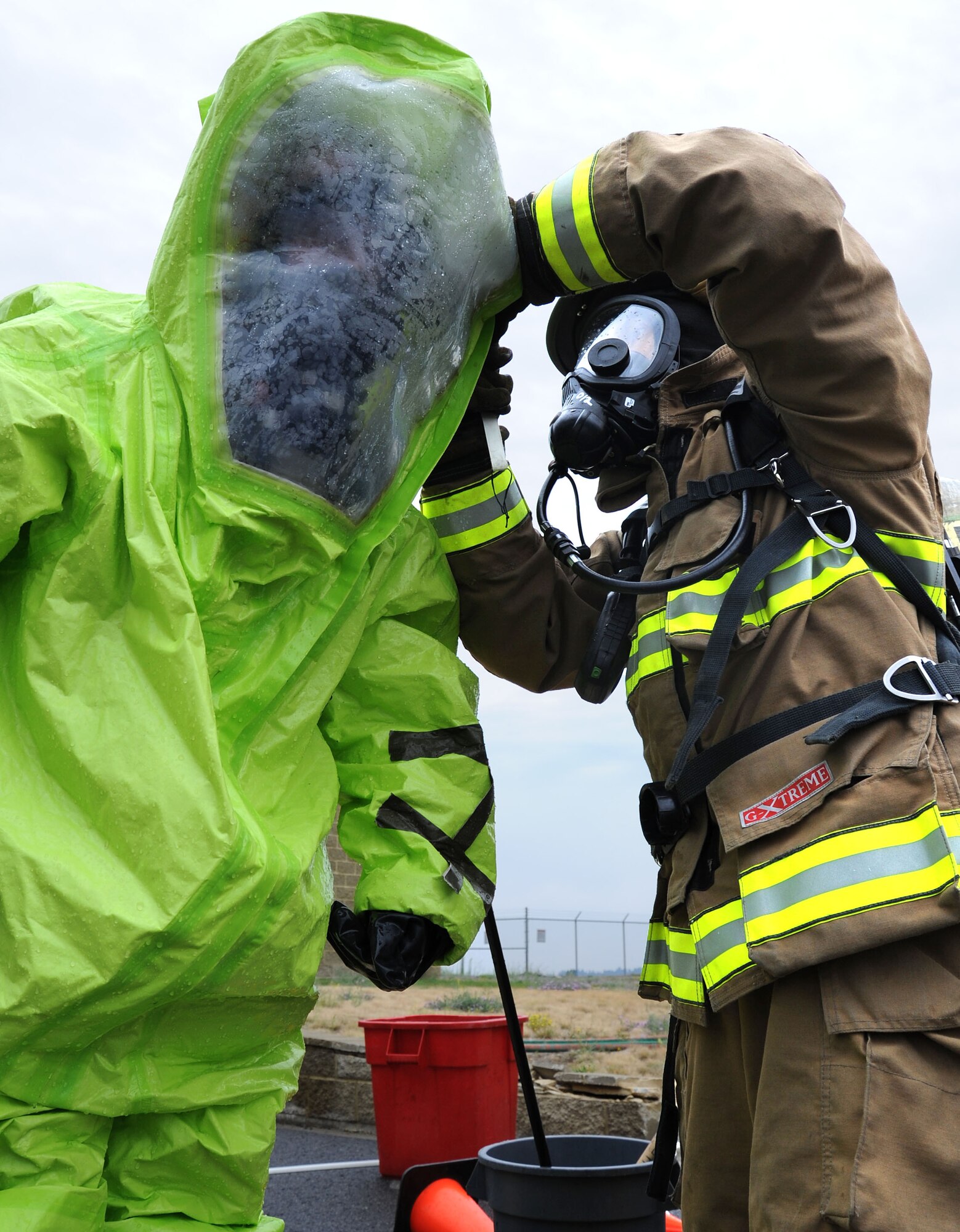 Airman 1st Class Bryan Schwinn, 92nd Civil Engineer Squadron firefighter, removes Staff Sgt. Jeremy Parks’, 92nd Civil Engineer Squadron emergency management craftsman, Level A suit after entering a contaminated zone during a field exercise at Fairchild Air Force Base, Wash., Aug. 1, 2013. Bioenvironmental Engineering along with Emergency Management and Fire participated in four Chemical, Biological, Radiological and Nuclear Defense focused Integrated Base Emergency Response Capability Training field exercises. (U.S. Air Force photo by Airman 1st Class Janelle Patiño/Released)