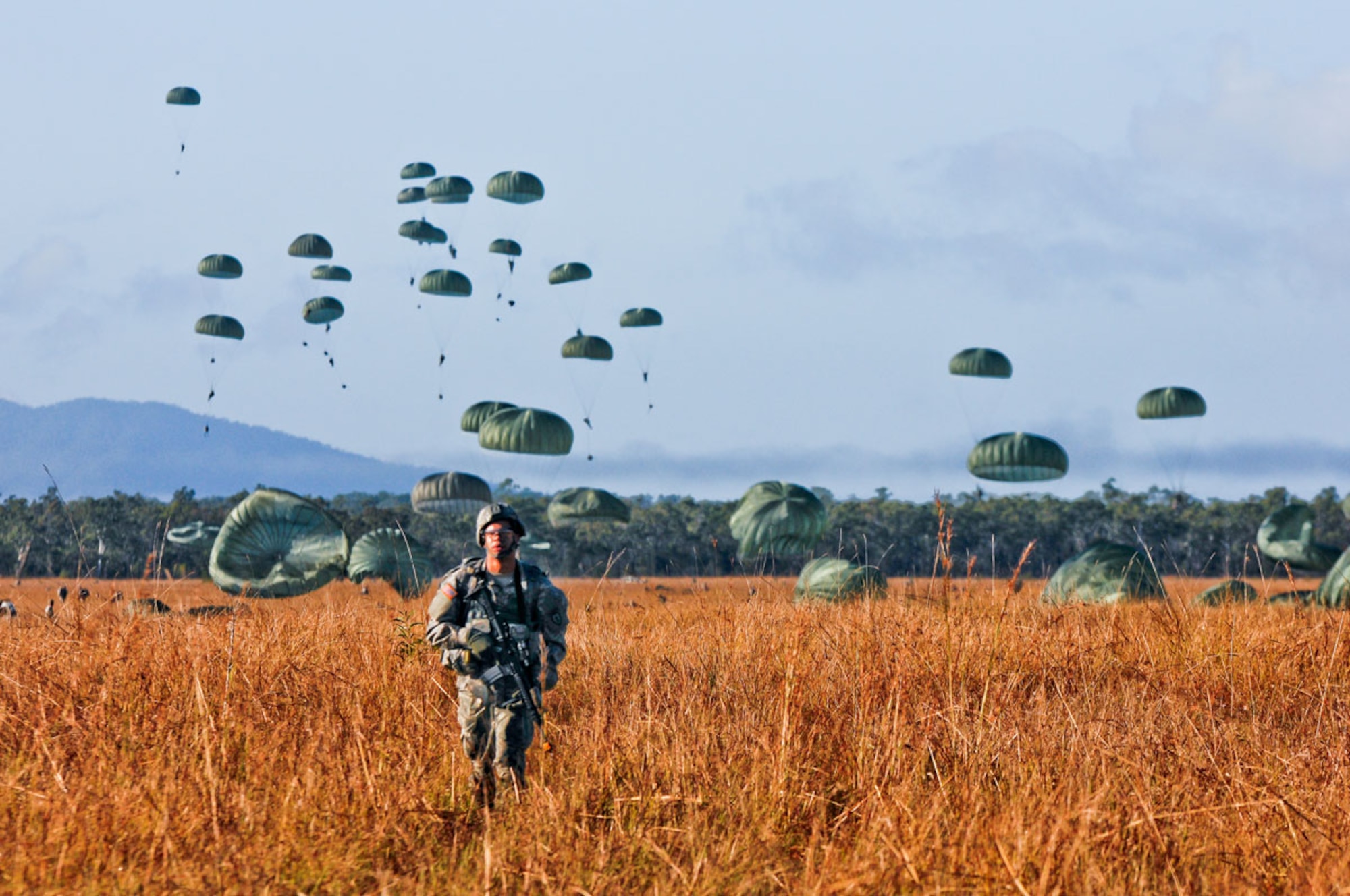 Paratroopers of the 4th Infantry Brigade Combat Team (Airborne), 25th Infantry Division, from Joint Base Elmendorf-Richardson, descend onto the drop zone and move out to follow-on objective points while conducting forced-entry operations during Talisman Saber 2013 at the Shoalwater Bay Training Area July 20 in Queensland, Australia. Talisman Saber features the United States and Australian bilateral alliance by showcasing their joint capabilities while training approximately 18,000 U.S. and 9,000 Australian personnel. (U.S. Army photo/Staff Sgt. Jeffrey Smith)