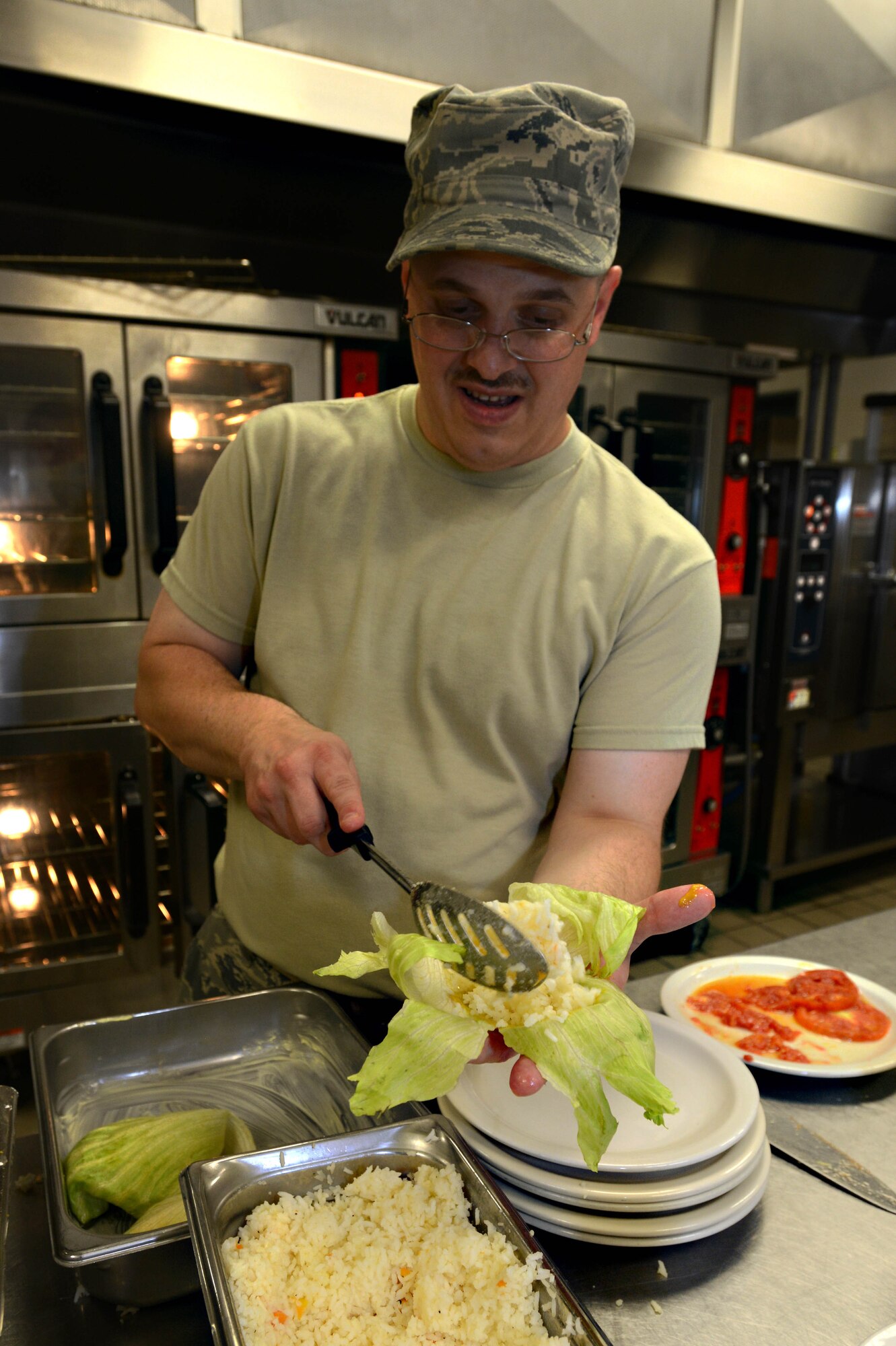 Staff Sgt. Matthew Franklin, 20th Force Support Squadron shift supervisor, places rice into a lettuce wrap during an Iron Chef competition at the Chief Master Sgt. Emerson Williams Dining Facility, Shaw Air Force Base, S.C., July 30, 2013. The competition was judged on two dishes prepared with the secret ingredient of papaya. (U.S. Air Force photo by Airman 1st Class Jensen Stidham/Released)