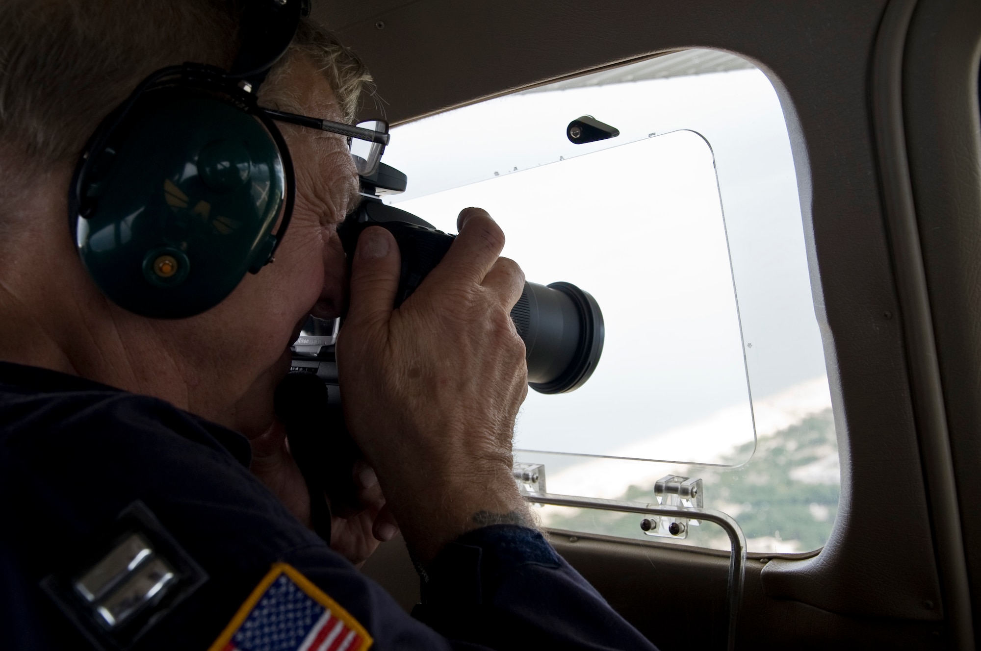 A Civil Air Patrol captain takes pictures of the coast line after a simulated hurricane makes landfall Aug. 3, 2013, south of Dover Air Force Base, Del. The training was conducted to prepare CAP for future hurricane missions.  (U.S. Air Force photo/Senior Airman Jared Duhon)