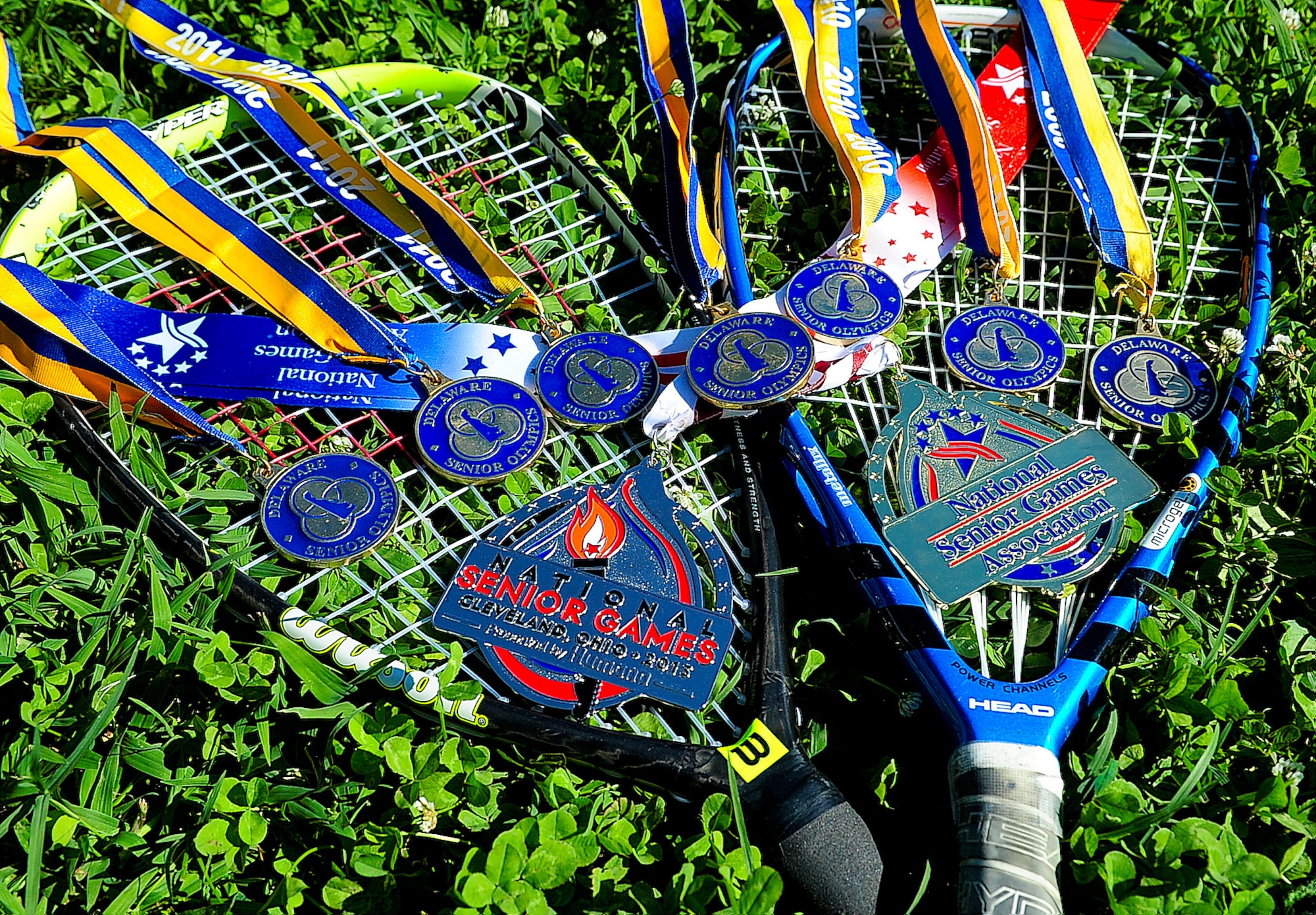 Racquetball awards belonging to William Dawkins, 85-year-old award winning racquetball player, lay on the ground Aug. 4, 2013, at his house in Clayton, Del. Dawkins won the silver in singles and the gold in doubles July 29 at the National Senior Games in Cleveland for racquetball. (U.S. Air Force photo/Airman 1st Class Ashlin Federick)
