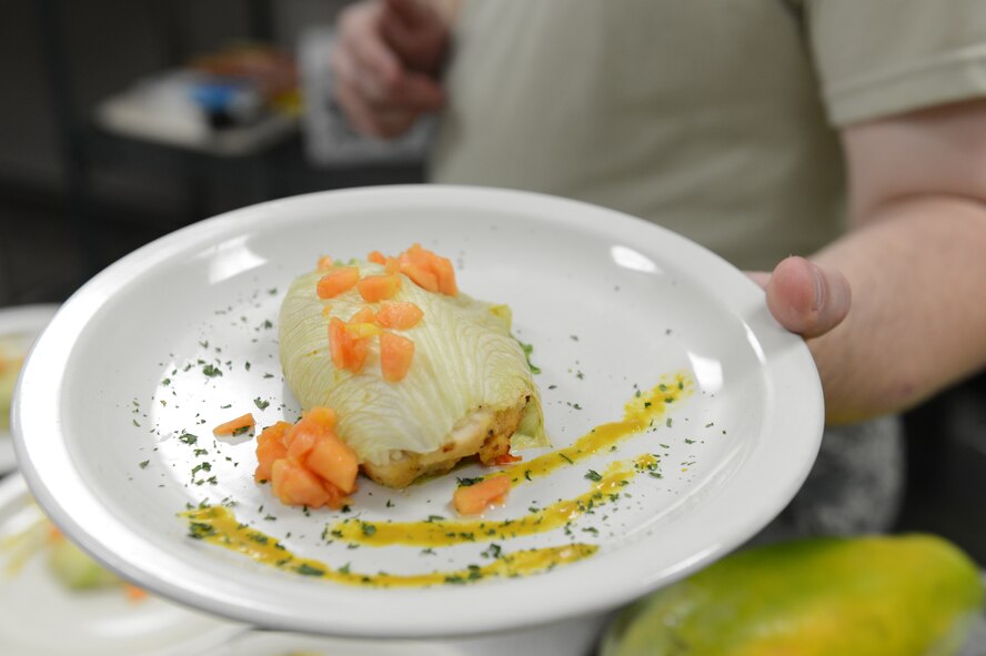 Staff Sgt. Matthew Franklin, 20th Force Support Squadron shift supervisor, displays his team’s mustard crusted chicken and rice wrapped in a corn husk dish during the Iron Chef competition at the Chief Master Sgt. Emerson Williams Dining Facility, Shaw Air Force Base, S.C., July 30, 2013. There were three teams and they had to make an entrée and appetizer for six people in 90 minutes. (U.S. Air Force photos by Airman 1st Class Krystal M. Jeffers/Released)