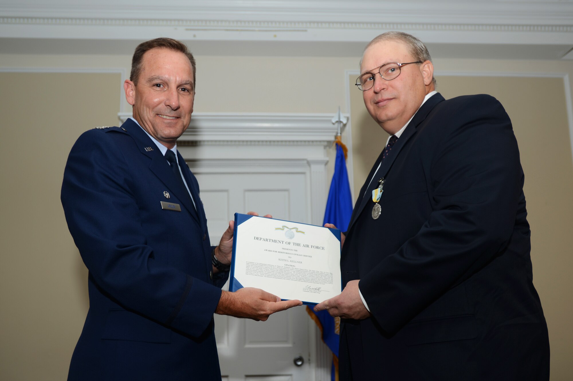 U.S. Air Force Col. Scott Arcuri, 20th Mission Support Group commander, presents Keith Kellner, 20th MSG deputy director for installations, a certificate of appreciation at his promotion ceremony here at Shaw Air Force Base S.C., July 29, 2013.  Kellner was promoted from GS-14 to GS-15 and will also be taking a new position at Scott AFB, Ill. (U.S. Air Force photo by Airman 1st Class Jensen Stidham/Released)