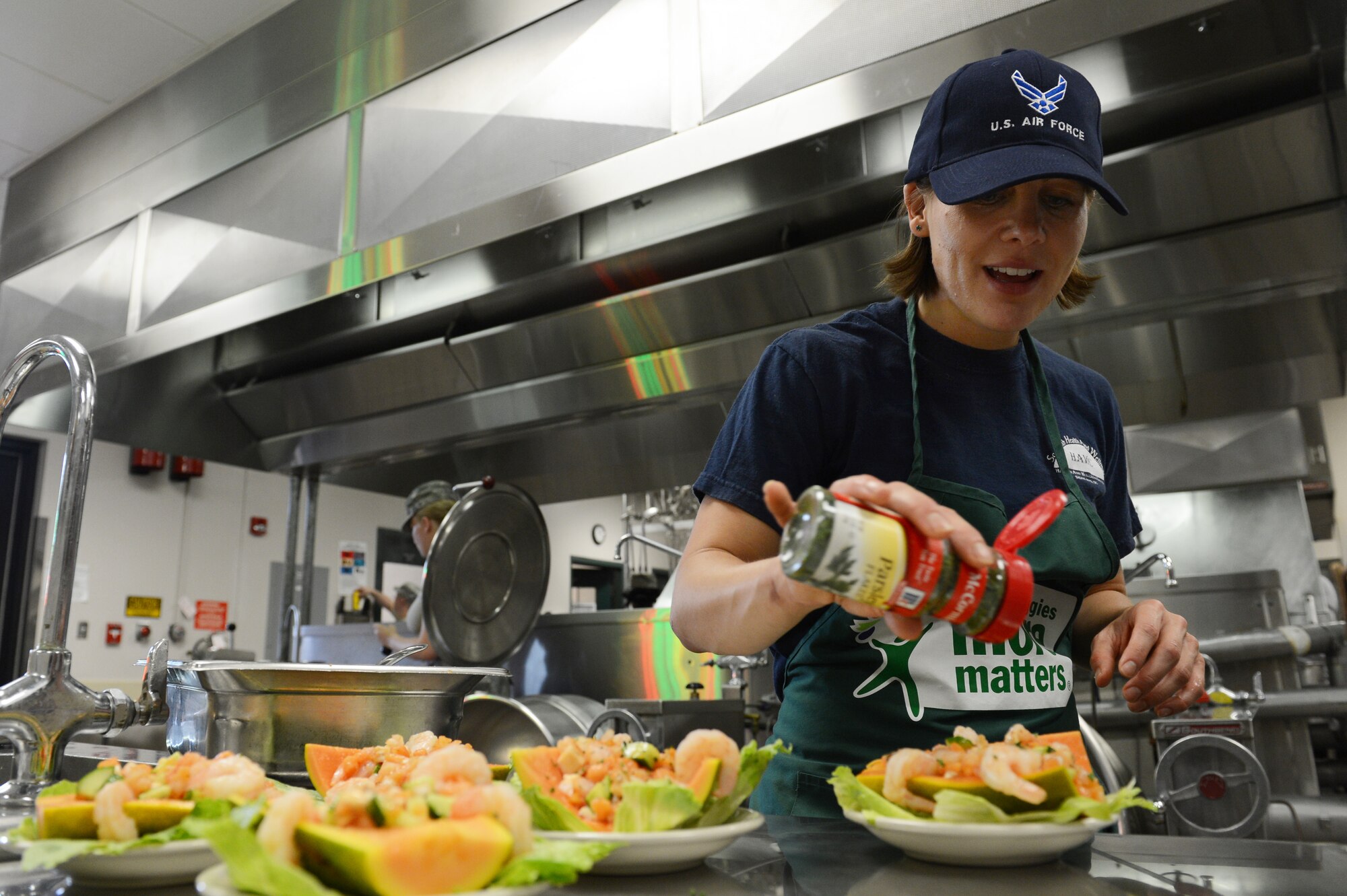 Janine Reinhdtz, 20th Force Support Squadron registered dietitian, decorates her team’s shrimp and papaya salad with parsley during the Iron Chef competition at the Chief Master Sgt. Emerson Williams Dining Facility Shaw Air Force Base, S.C.,, July 30, 2013. Her team represented the20th FSS and included Airman 1st Class Alyssa Hason, force management journeyman, and Staff Sgt. Melissa Chartier, NCO in charge of outbound assignments. They made chicken and rice with papaya as their entrée to complement their salad appetizer. (U.S. Air Force photo by Airman 1st Class Krystal M. Jeffers/Released)
