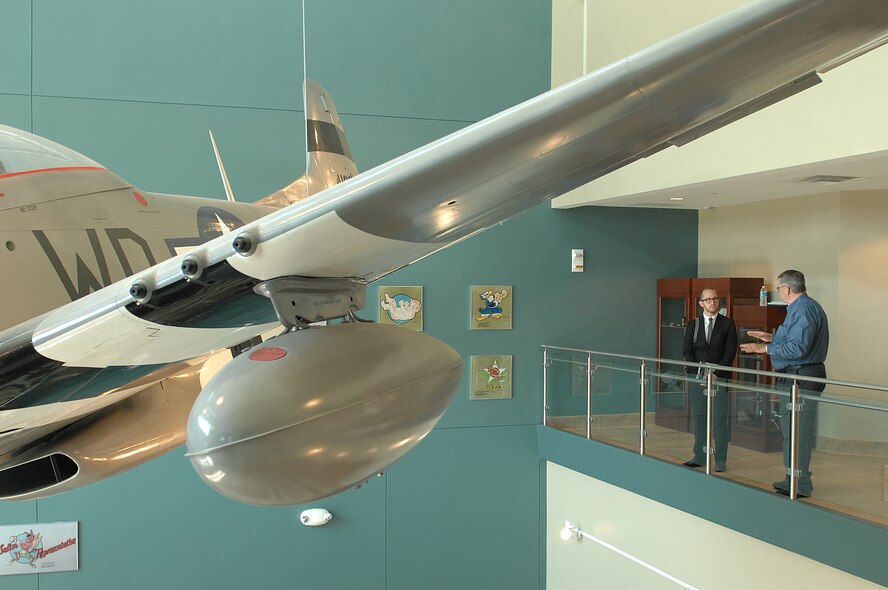 Dr. Roy Heidicker, 4th Fighter Wing historian, shows a display of a P-51 Mustang to Thomas Nash, grandson of retired Col. Van Chandler, during his visit to Seymour Johnson Air Force Base, N.C., Aug. 5, 2013.   Chandler flew the Mustang during World War II and at 19-years-old became the war’s youngest ace, a pilot credited with five or more aerial victories, having four ground and five confirmed aerial kills.  (U.S. Air Force photo by Airman 1st Class Brittain Crolley/Released)